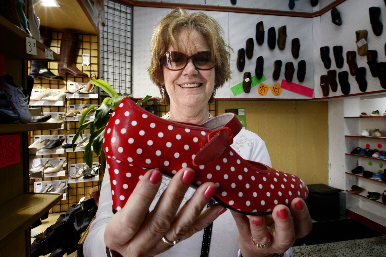 Una turista extranjera muestro un zapato de flamenca en un comercio de Cádiz.