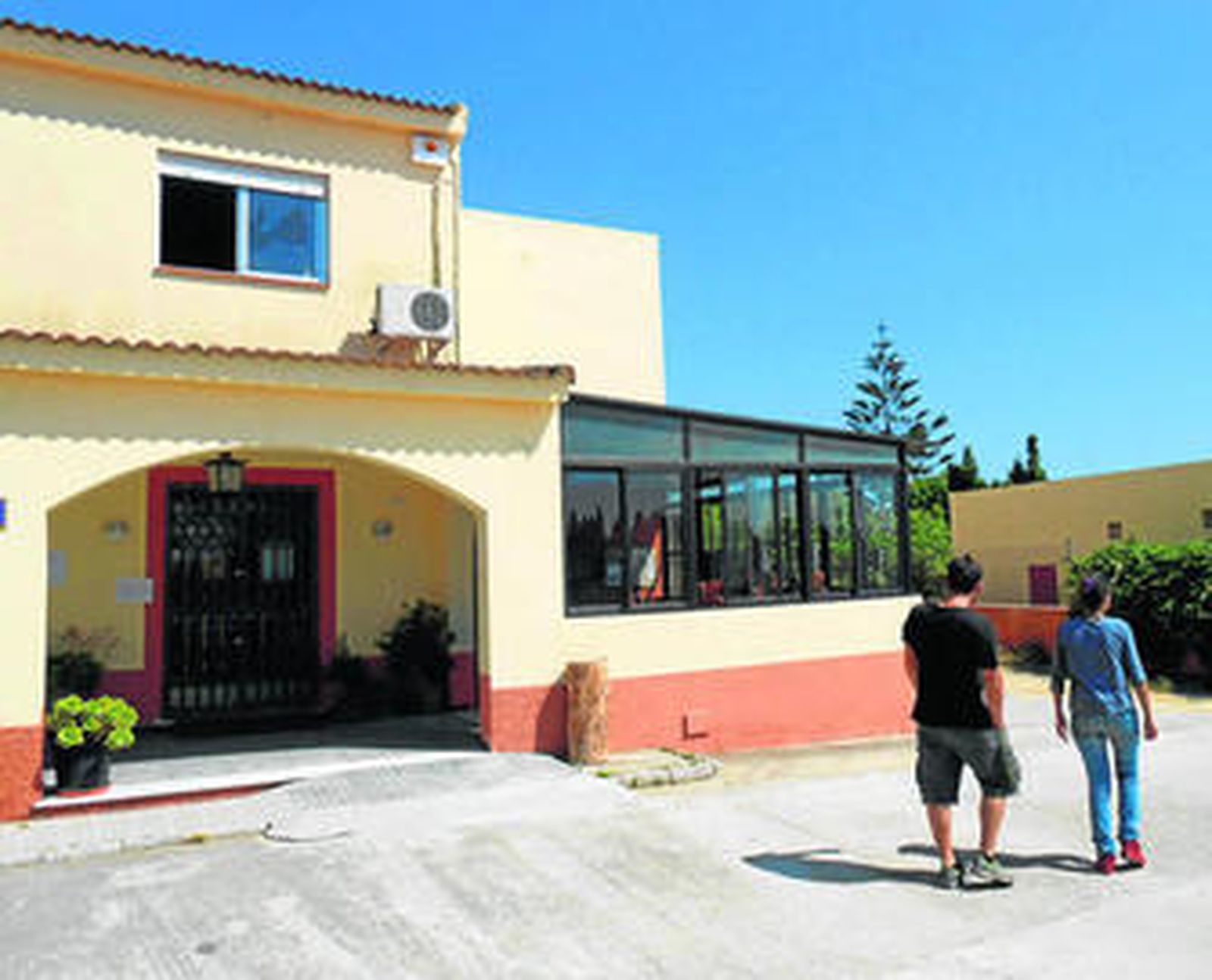 Los gerentes del Cotaller comprueban el exterior de la venta, ante la ventana por la que accedieron.