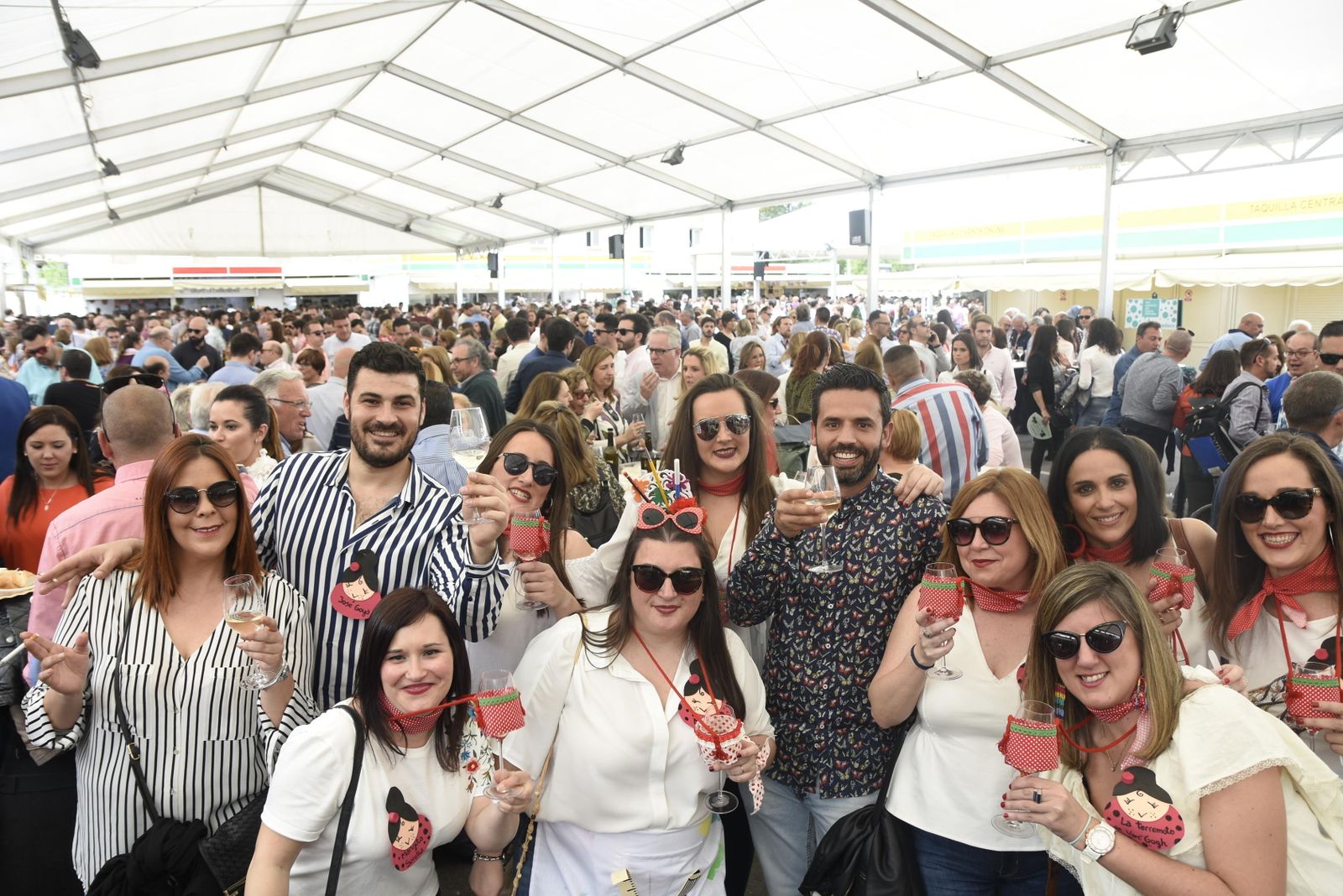 Un grupo de jóvenes posa en un pabellón repleto de gente.