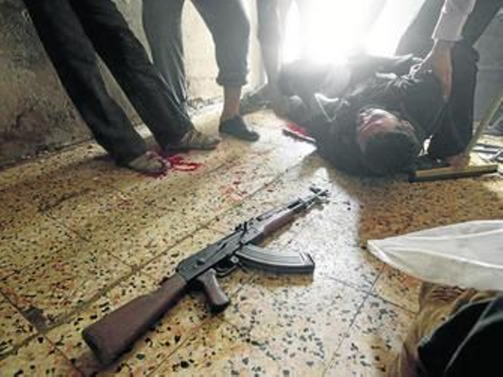 Un miembro del ELS herido en la pierna ayer en Alepo es ayudado por sus compañeros.