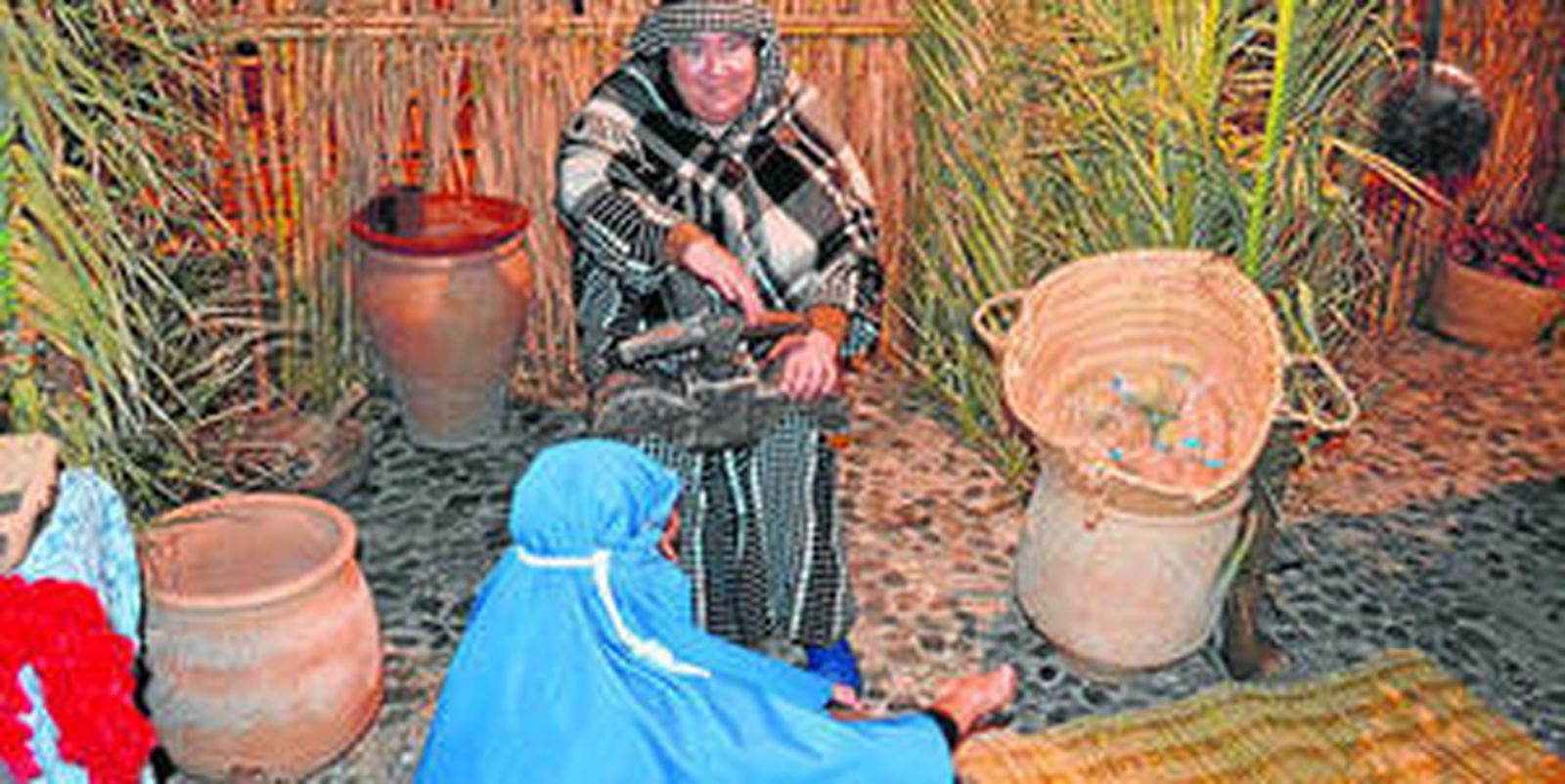 Dos personajes del Belén viviente de Tarifa, atareados con la molienda.