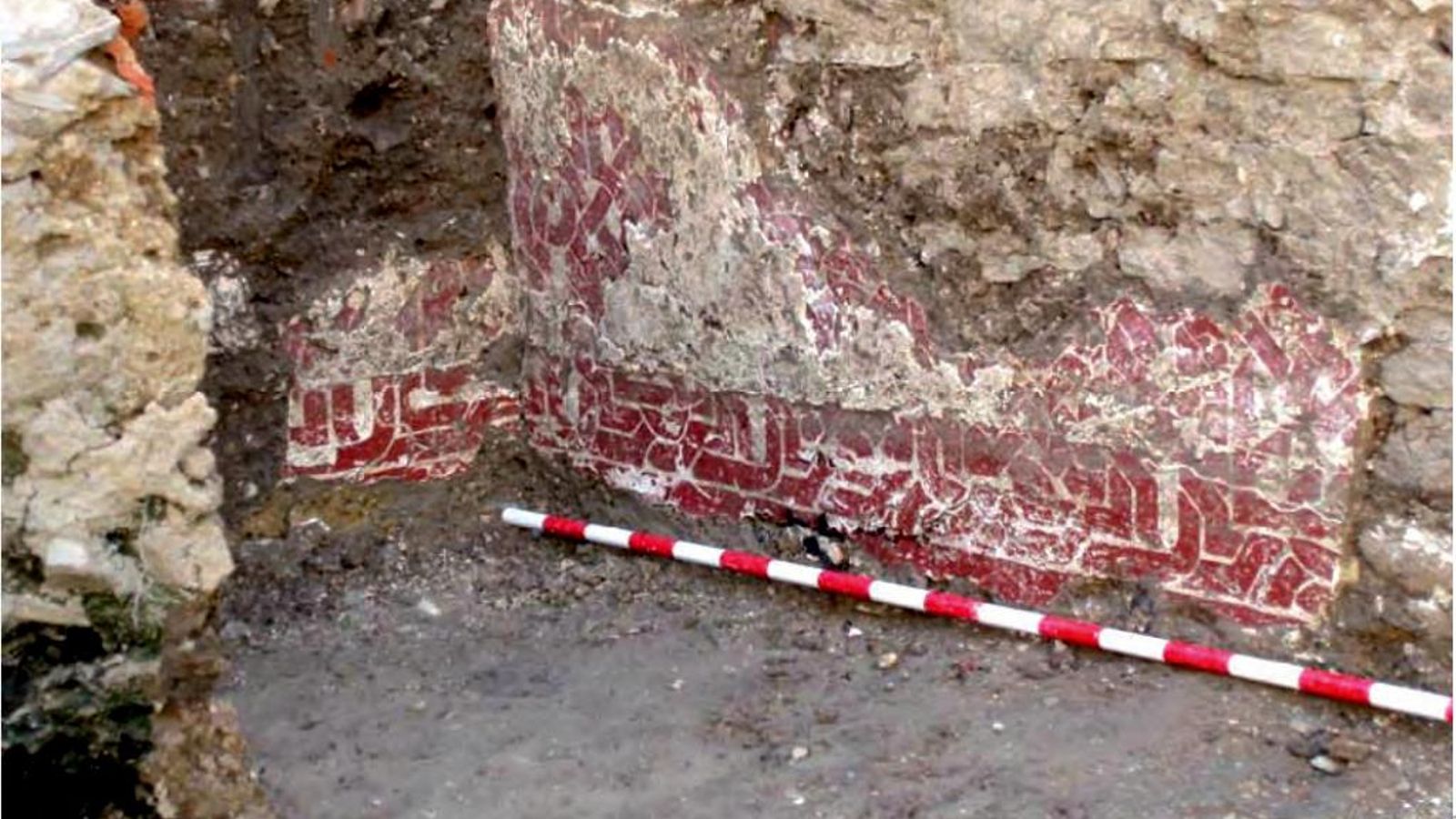 Decoración parietal consistente en entrelazos realizados con pintura roja hallada en una de las estancias de la vivienda musulmana excavada en el solar nº 11-13 de la calle Las Huertas de Algeciras.
