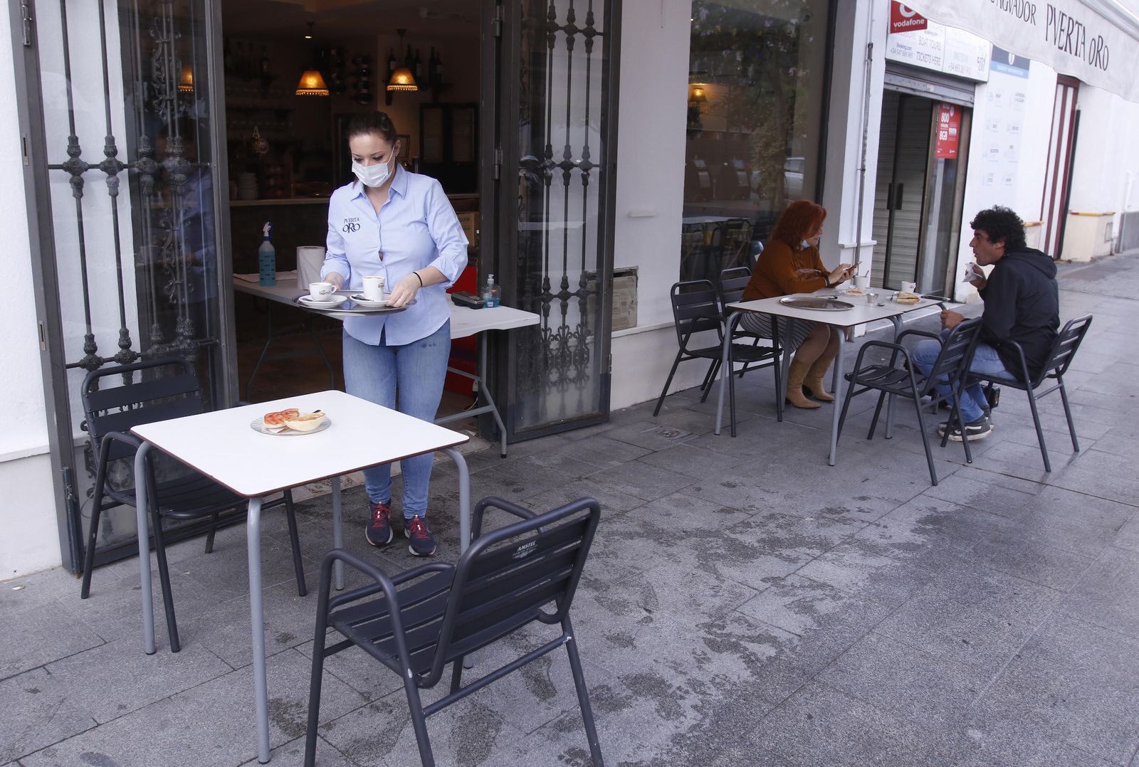 Una camarera sirve desayunos en un bar de Sevilla.