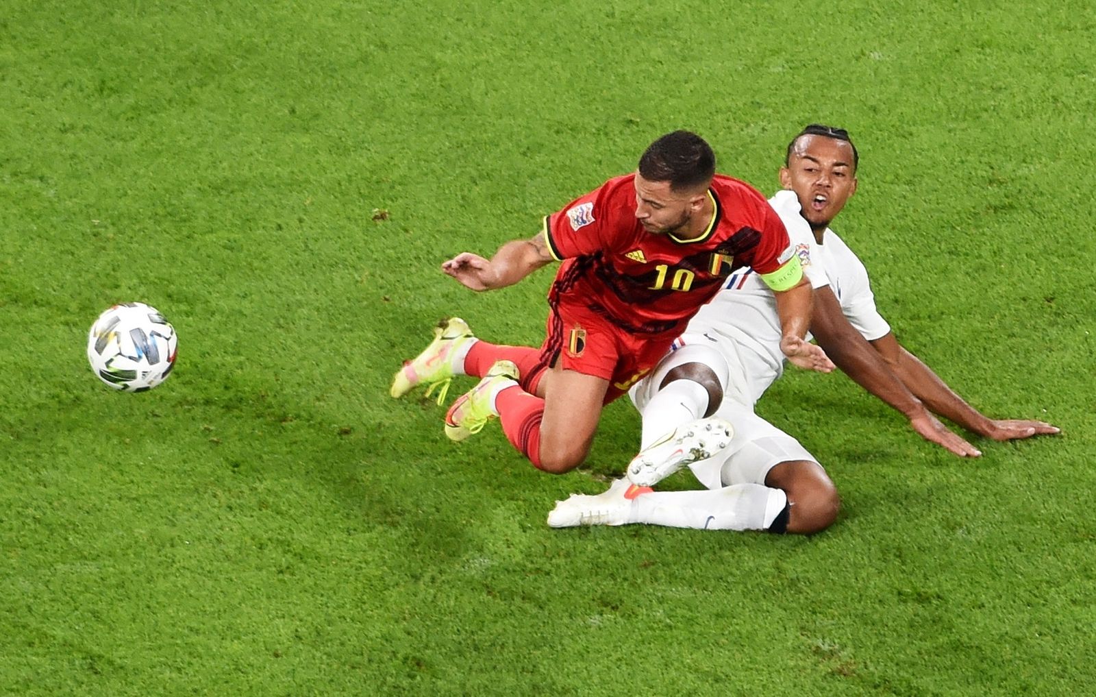 Koundé se tira a ras del césped para cortar un avance de Hazard.