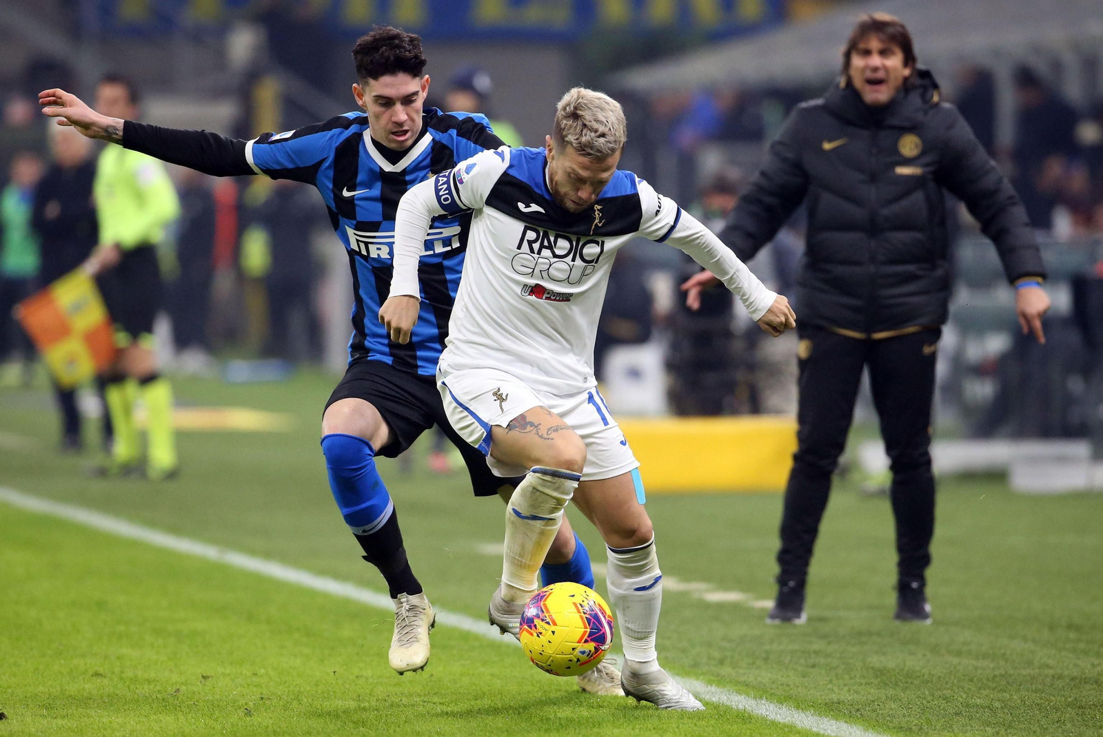 Papu Gómez aguanta la presión de Bastoni ante Antonio Conte en un Inter-Atalanta.