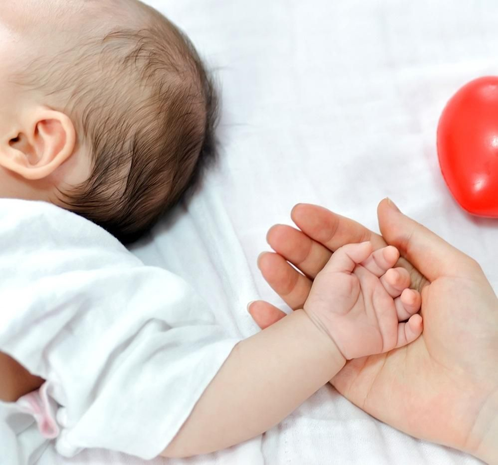 Una madre da la mano a su bebé.