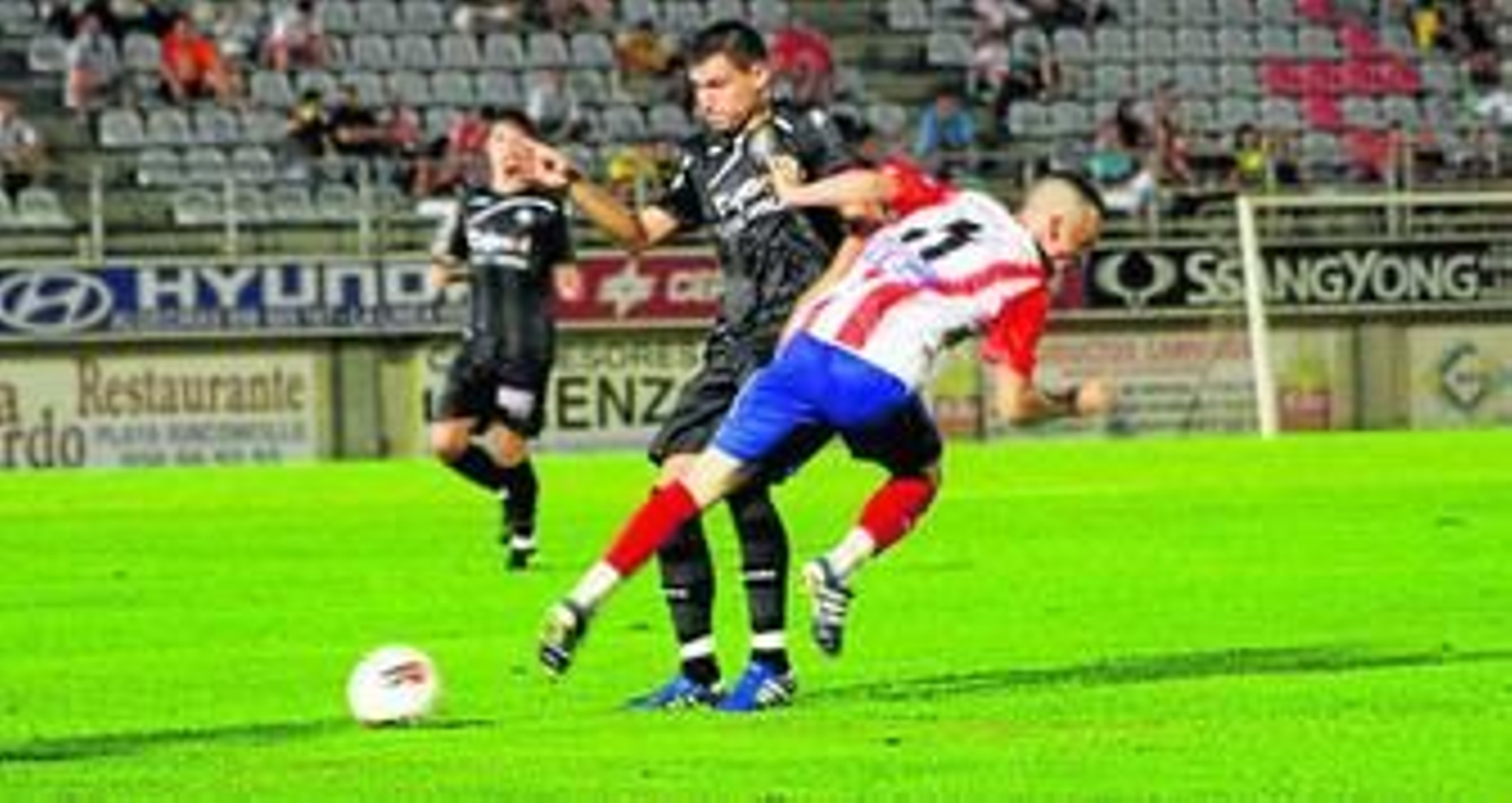 El linense del Recre Álex Quillo frena al algecireño Alvi Carrasco.