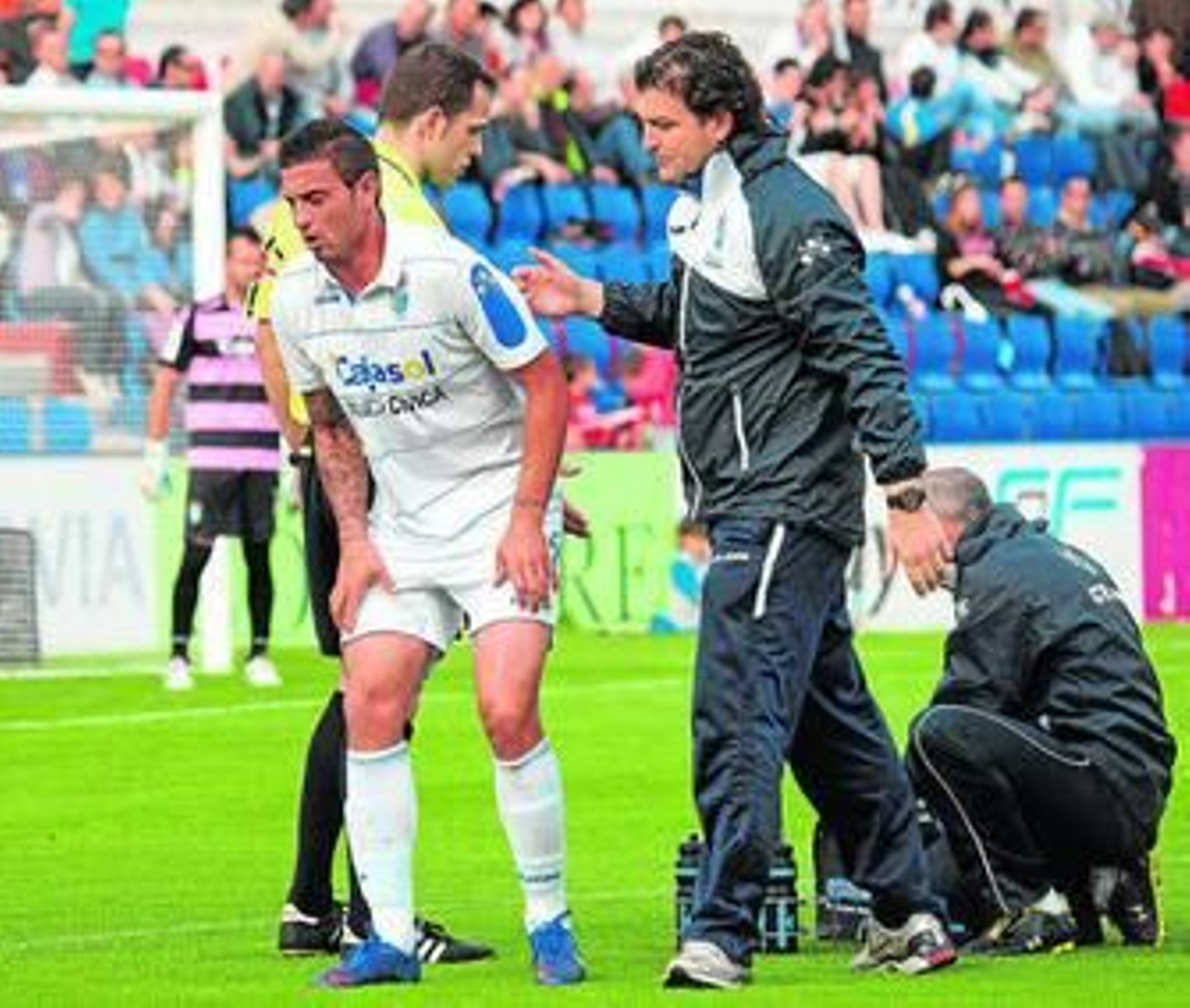 1. Rueda se incorpora con gesto de dolor junta a Fabián Belmonte, médico del Xerez, tras ser atendido por el galeno y por Carli, fisioterapeuta azulino, de un fuerte golpe en el muslo que no le impidió acabar el partido. 2. El Xerez no estuvo solo en El Alcoraz, como prueban estos dos aficionados que exhiben con orgullo la bufanda con los colores del Deportivo. 3. Tato encara al exxerecista Luis García en la jugada en la que el atacante sería arrollado por Corona sin que el árbitro señalase penalti. 4. Mendoza no esconde su enfado con Valdés Aller tras mostrarle el colegiado la amarilla. 5. Los defensas del Huesca no pueden impedir el disparo de Rueda, Luis García fija su mirada en el balón pero no lograría atajarlo en lo que significó el 2-1. / FOTOS: LOF y www.elobservadordelmundo.com