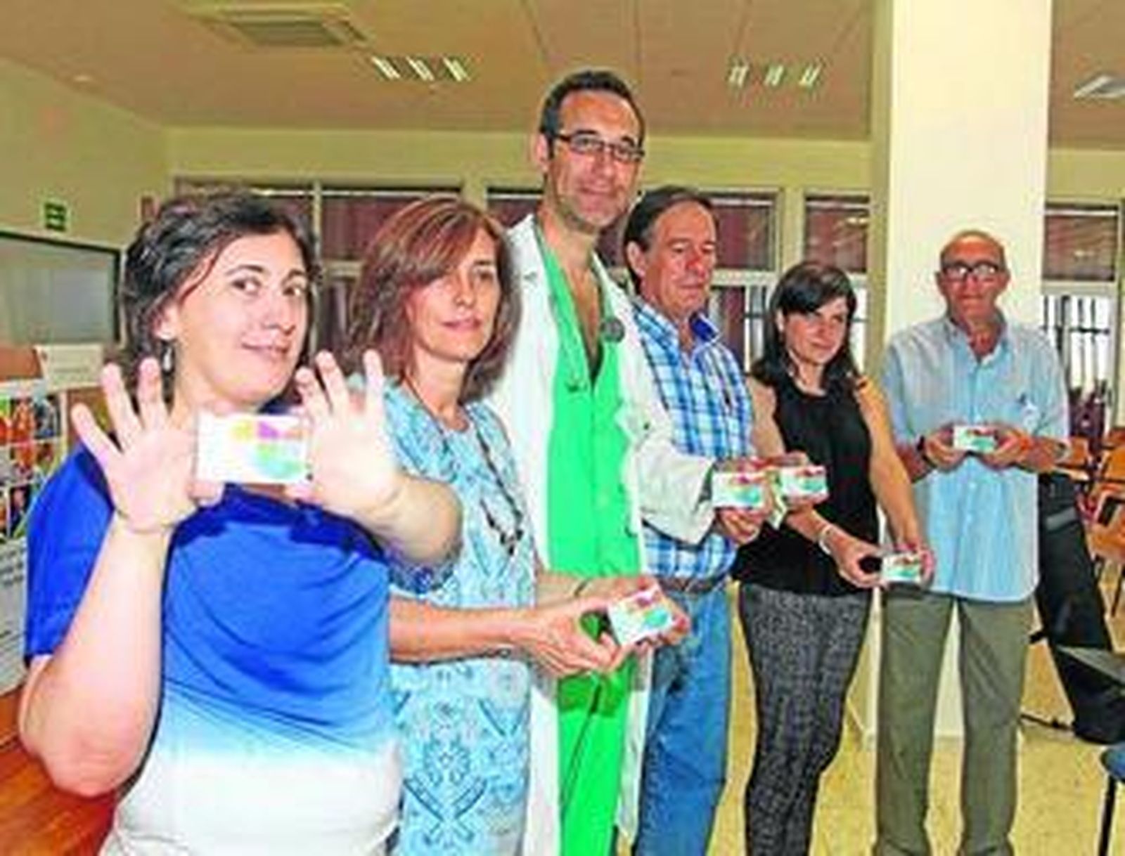 Coordinadores y pacientes posan con las tarjetas de donantes.