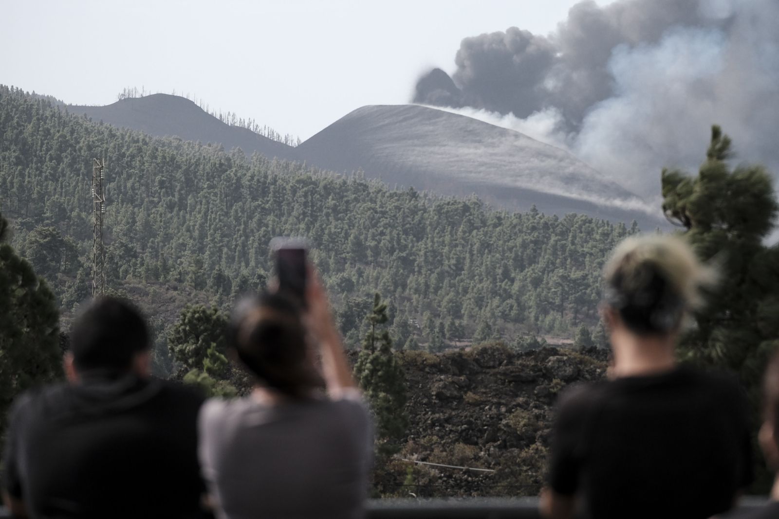 Varias personas miran atentos al volcán