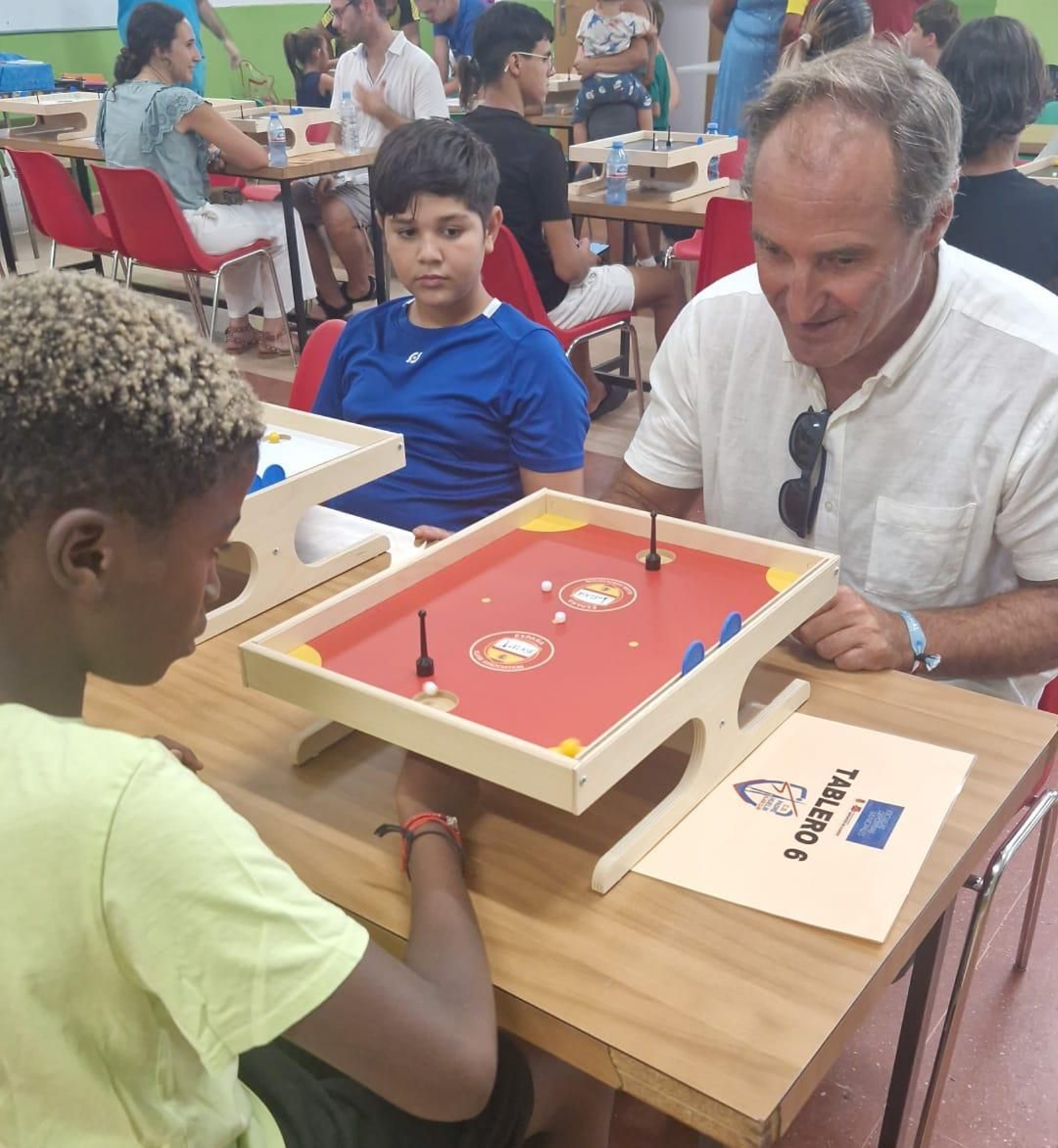 El concejal disputa una partida de klask contra uno de los chicos participantes en esta actividad.