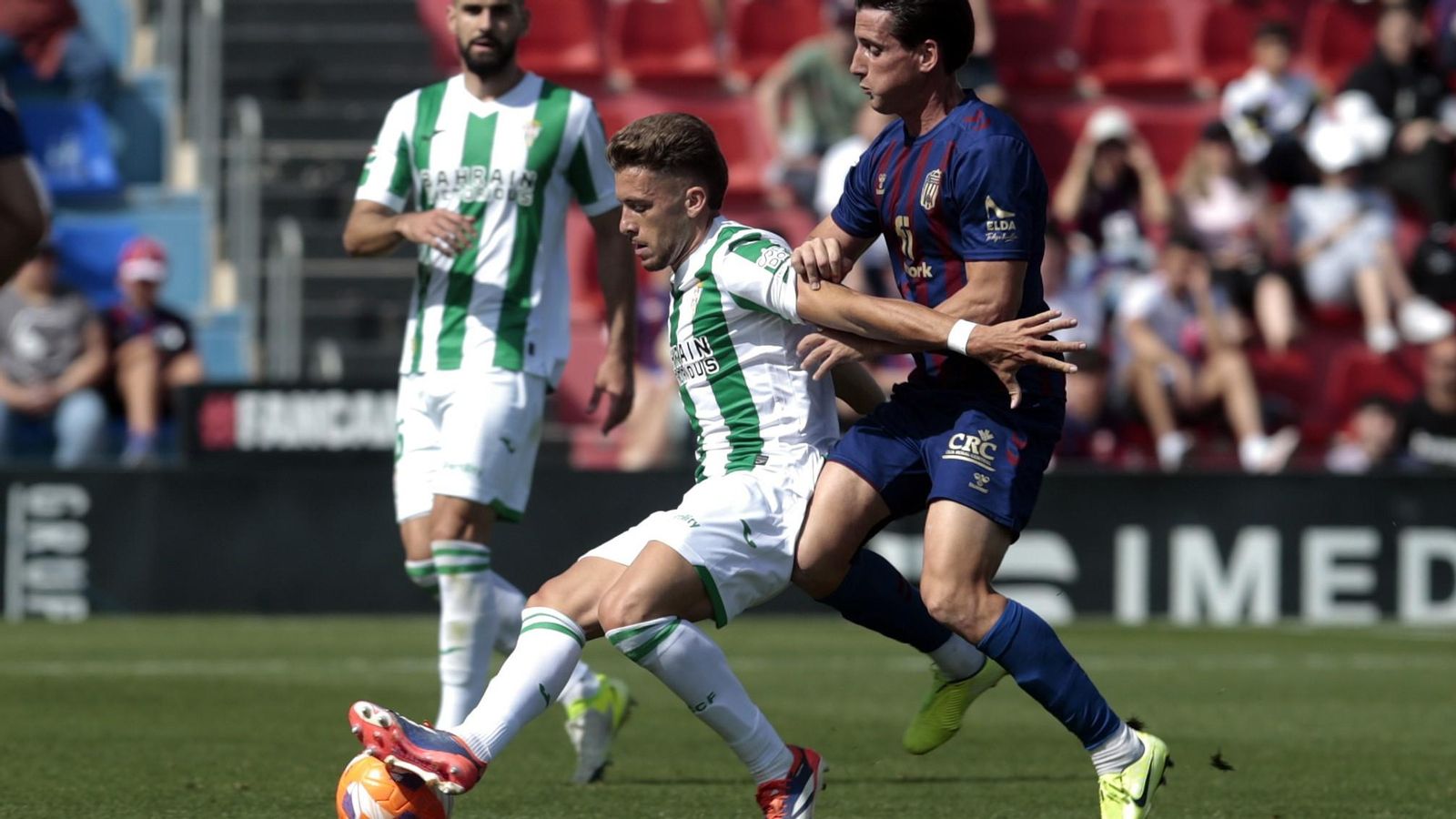Isma Ruiz protege el balón ante Juanto Ortuño en el Eldense - Córdoba CF.