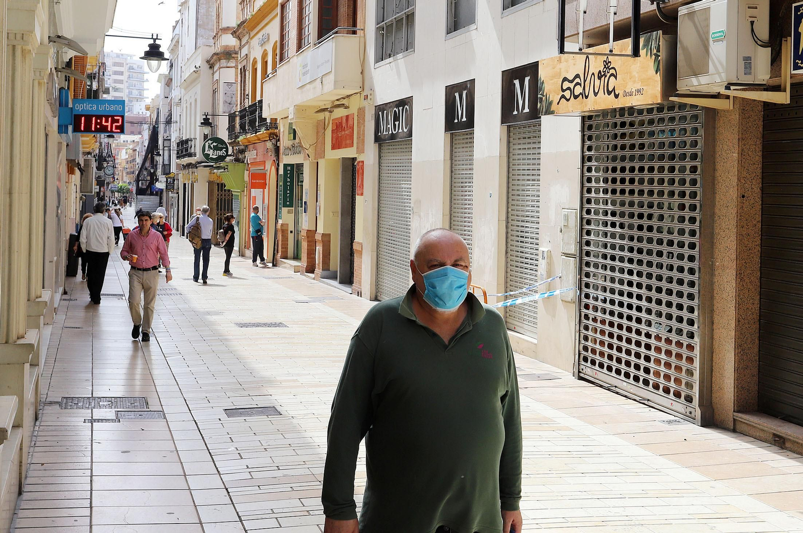 Un hombre camina por el centro de Huelva ante la mayoría de los comercios cerrados.