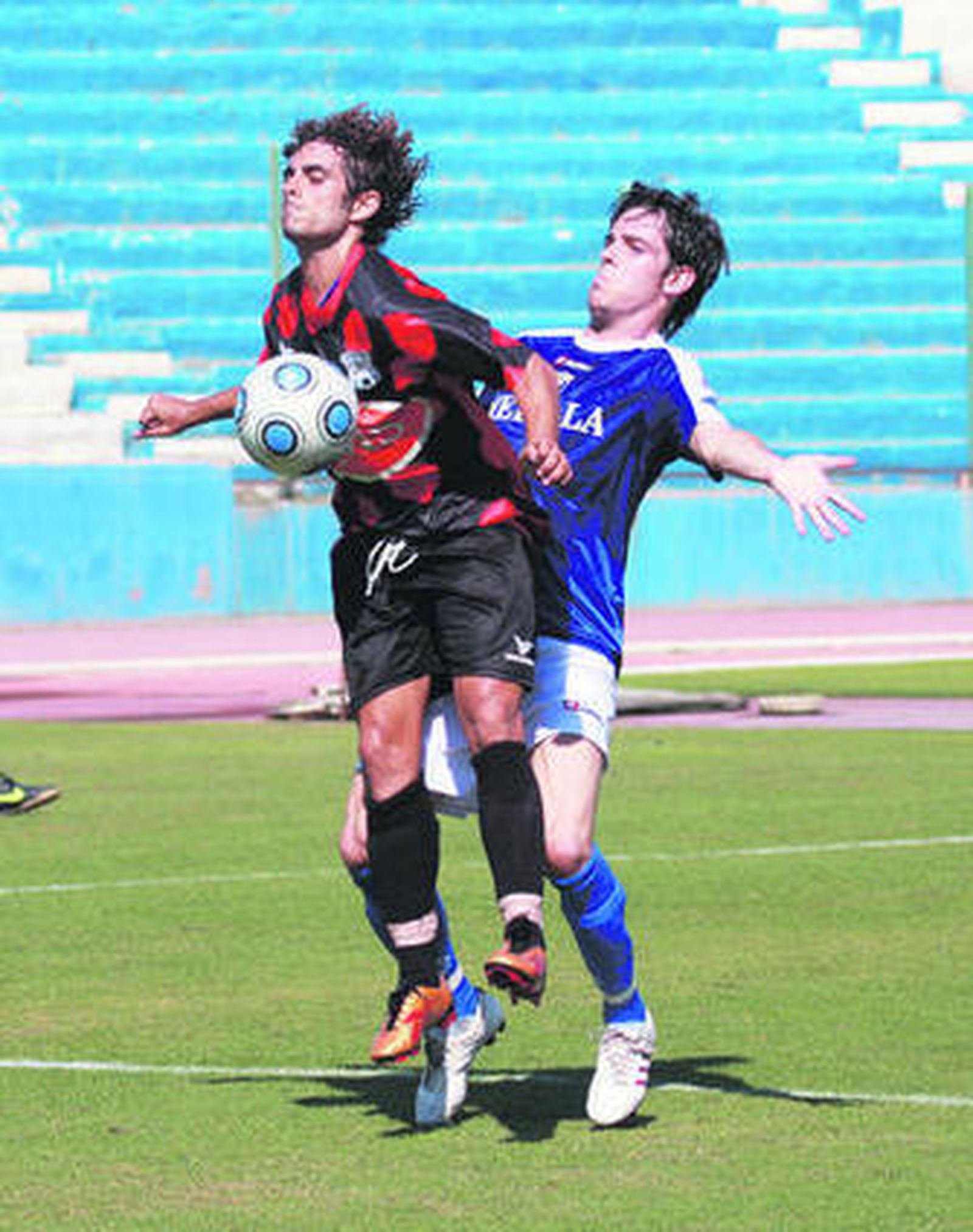 Benítez trata de controlar con el pecho presionado por un rival.