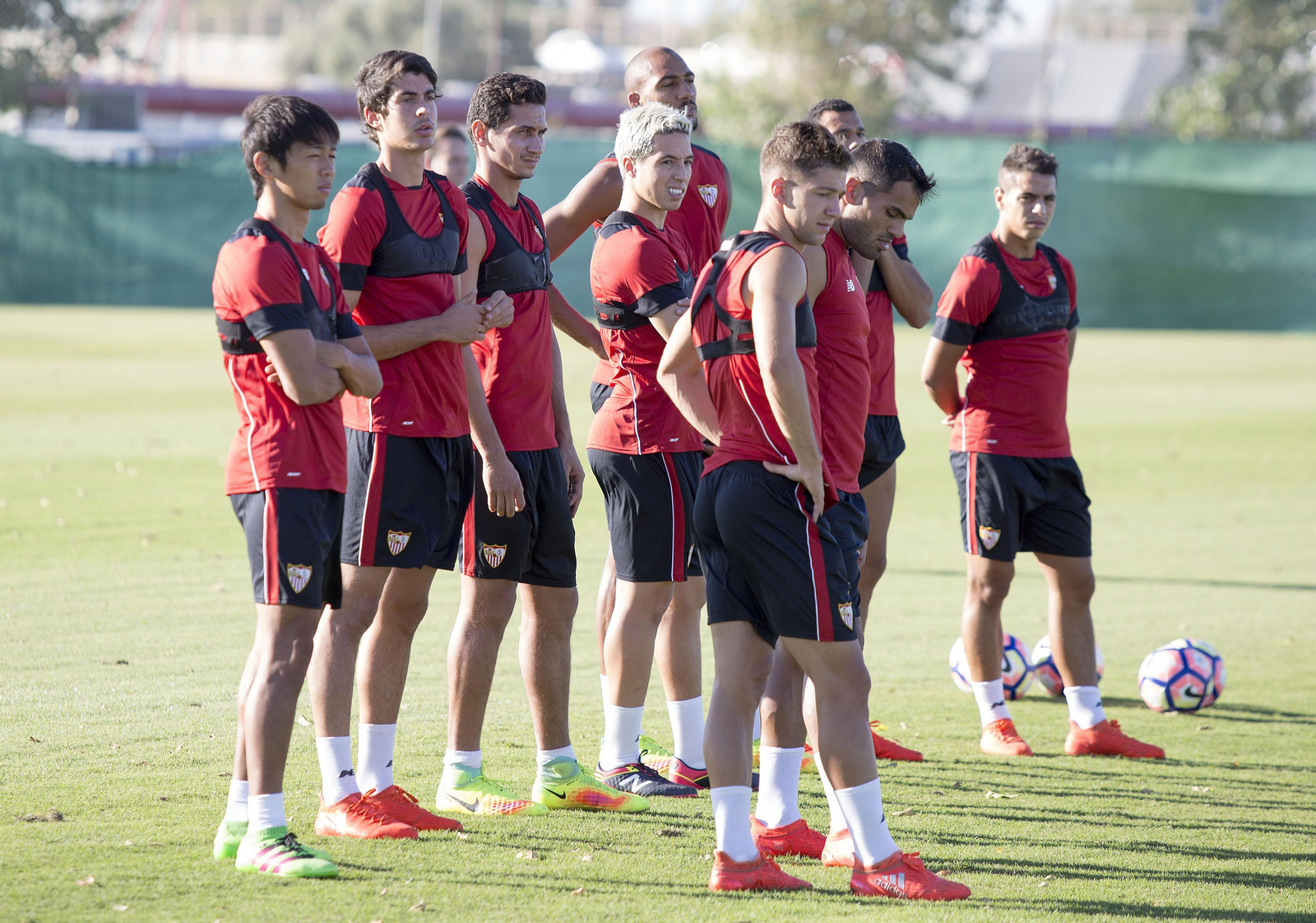 Varios jugadores del Sevilla esperan órdenes para una tarea en una sesión.
