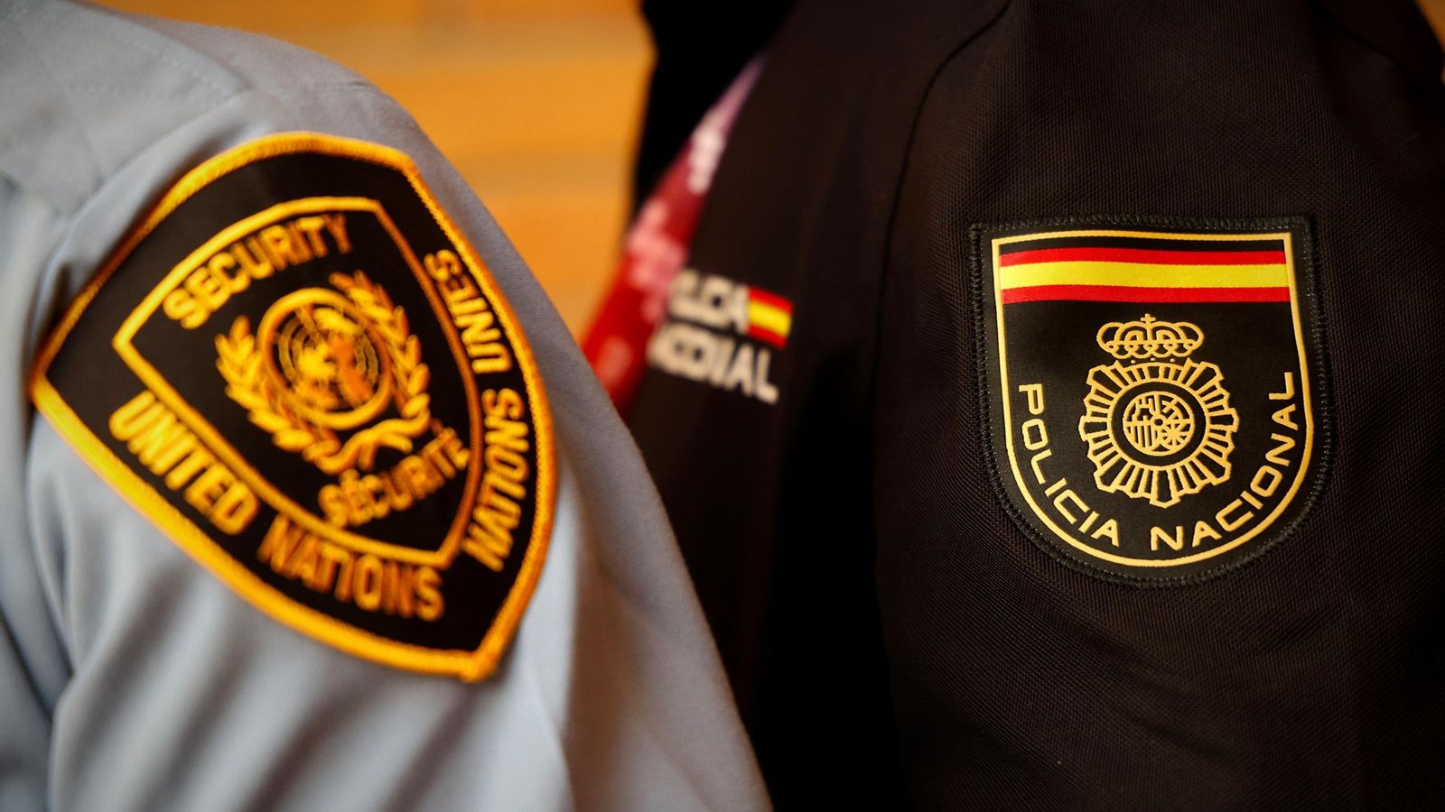 Un detalle de los emblemas de los cuerpos de seguridad de la ONU y de la Policía Nacional.