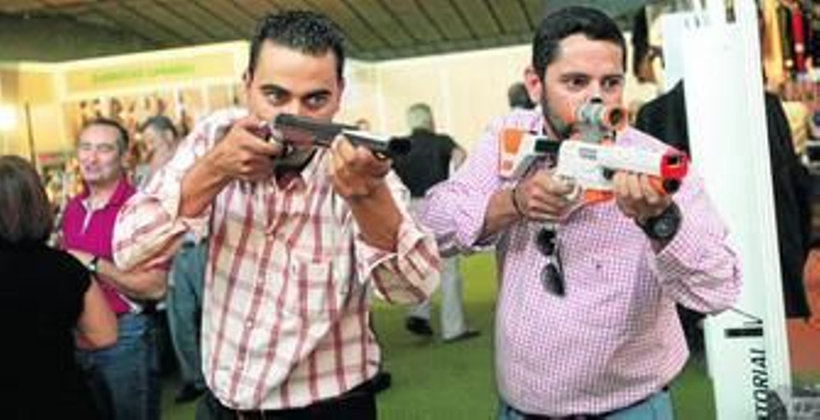 Dos personas prueban su puntería con una de las actividades de realidad virtual de la muestra.