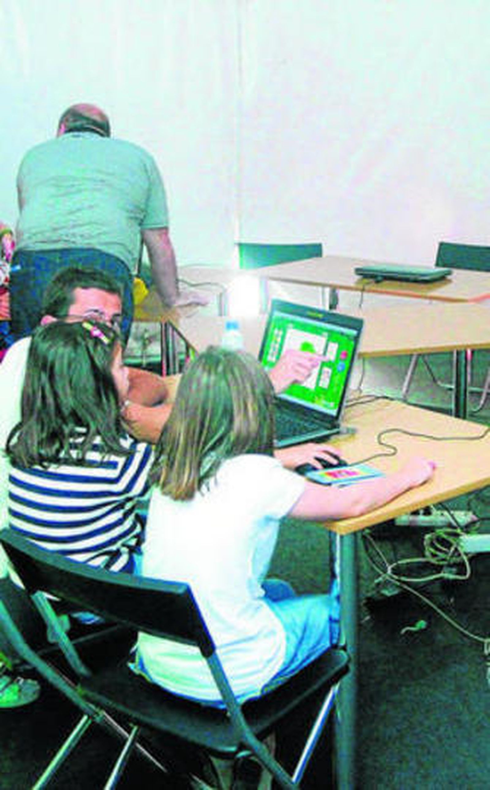 Varios niños, junto a unos ordenadores.