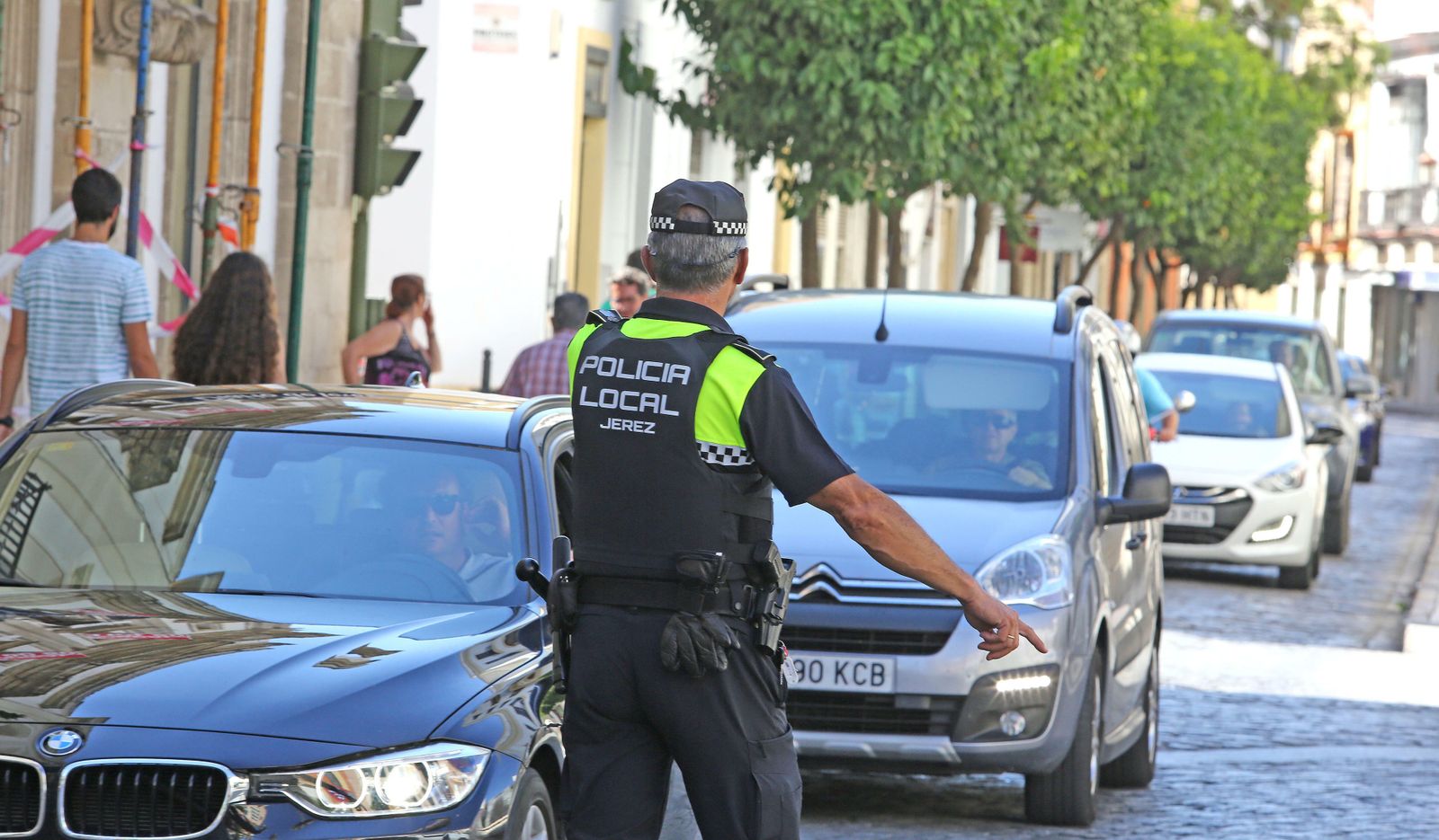 Un policía local ordena a un conductor que aparte su vehículo para pasar un control.