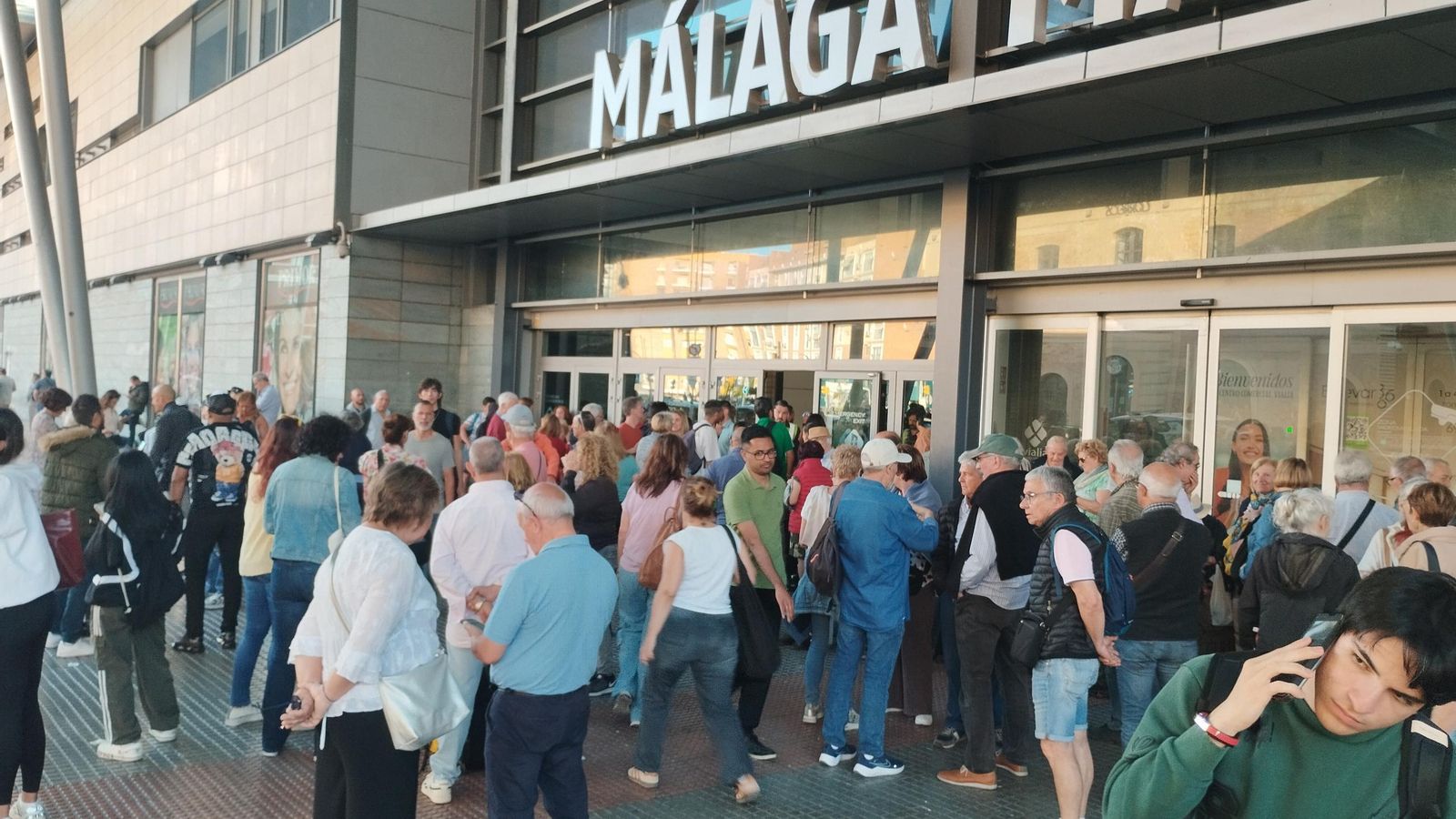 Viajeros de trenes cancelados, este lunes, ante la puerta principal de la estación María Zambrano.