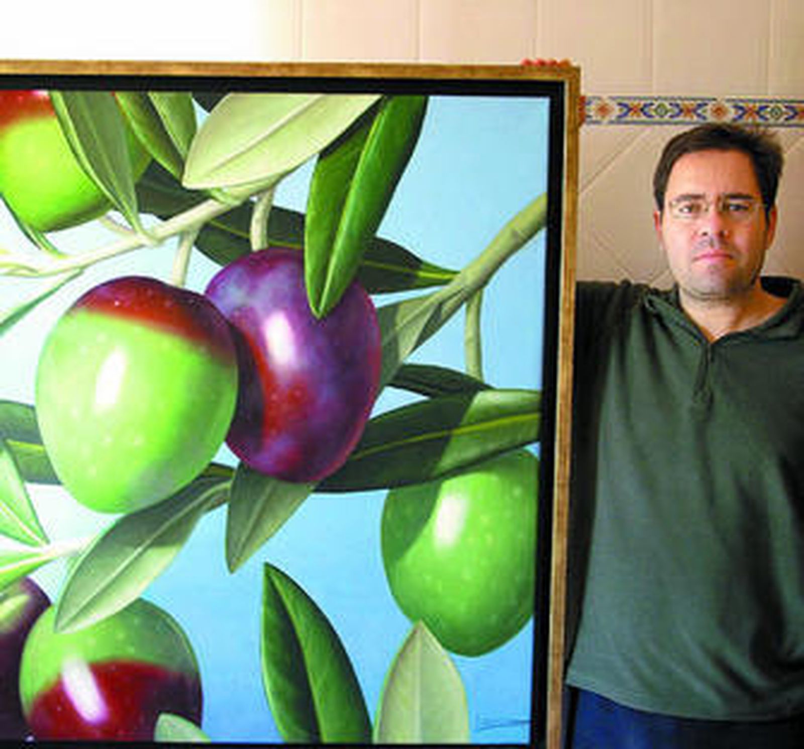 León Reina con una de las obras que expone en Argar.