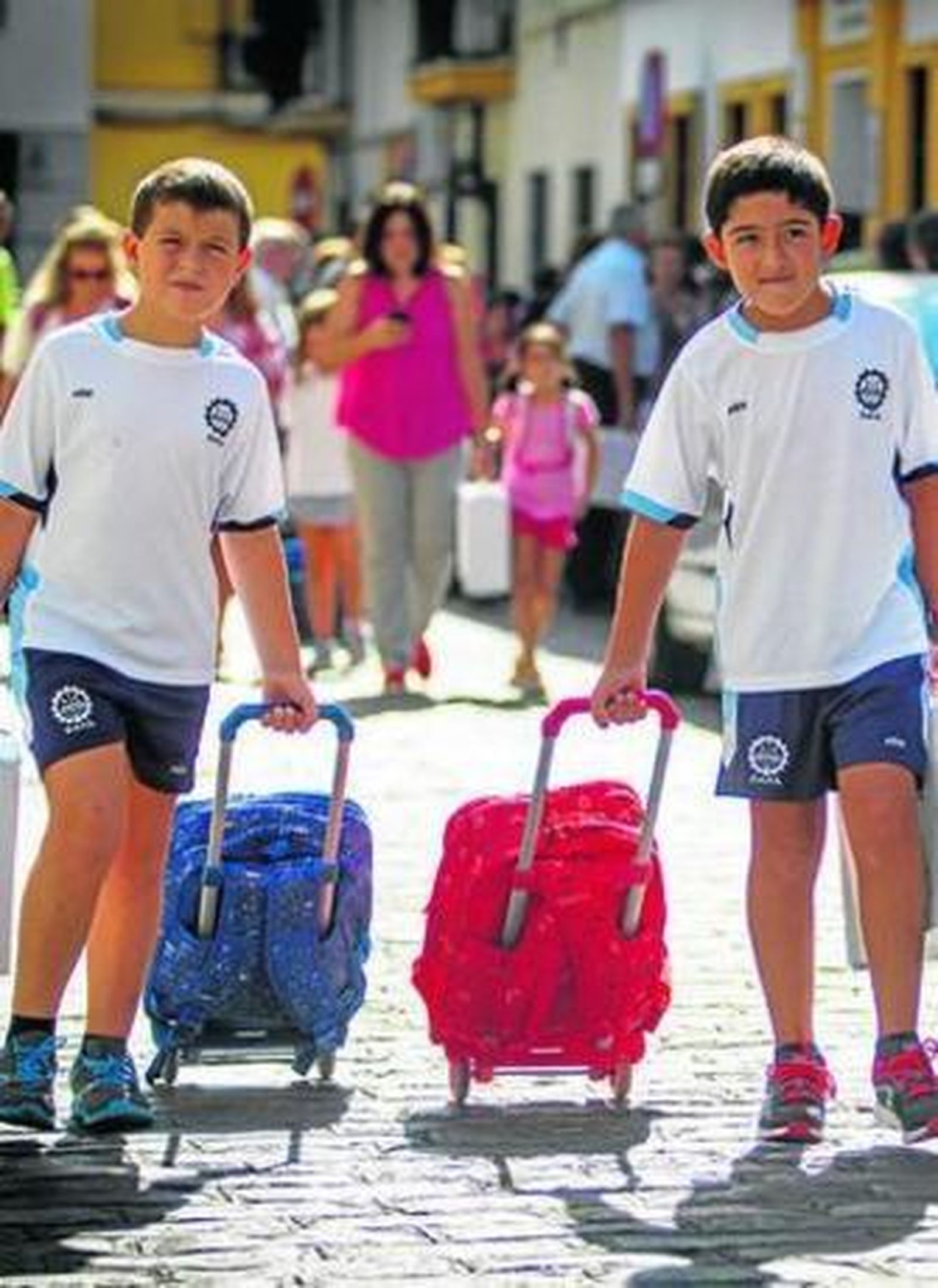 Dos chavales se dirigen al colegio la pasada semana con sus mochillas en sendos carritos.