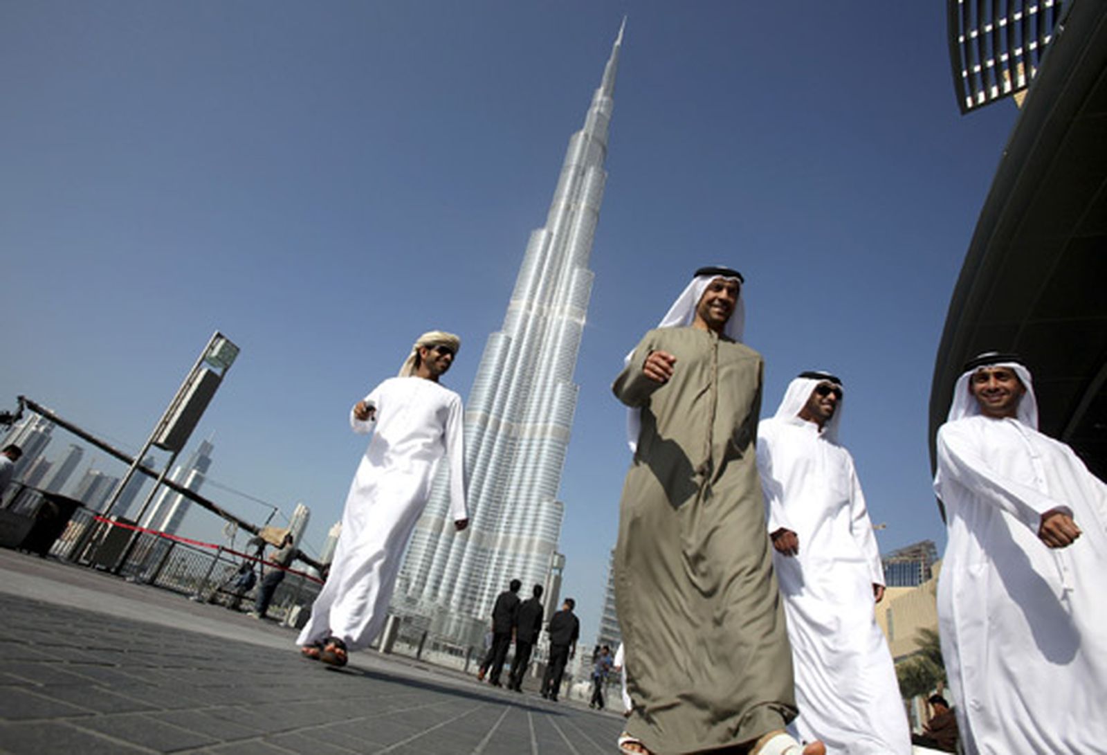 Un grupo de dubaitíes pasea bajo la Burj Dubai. / Reuters
