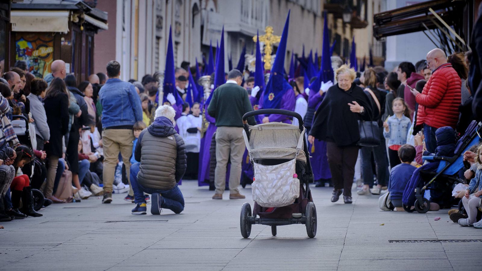 Mucha gente y un carrito delante de la cruz de guía de Afligidos.