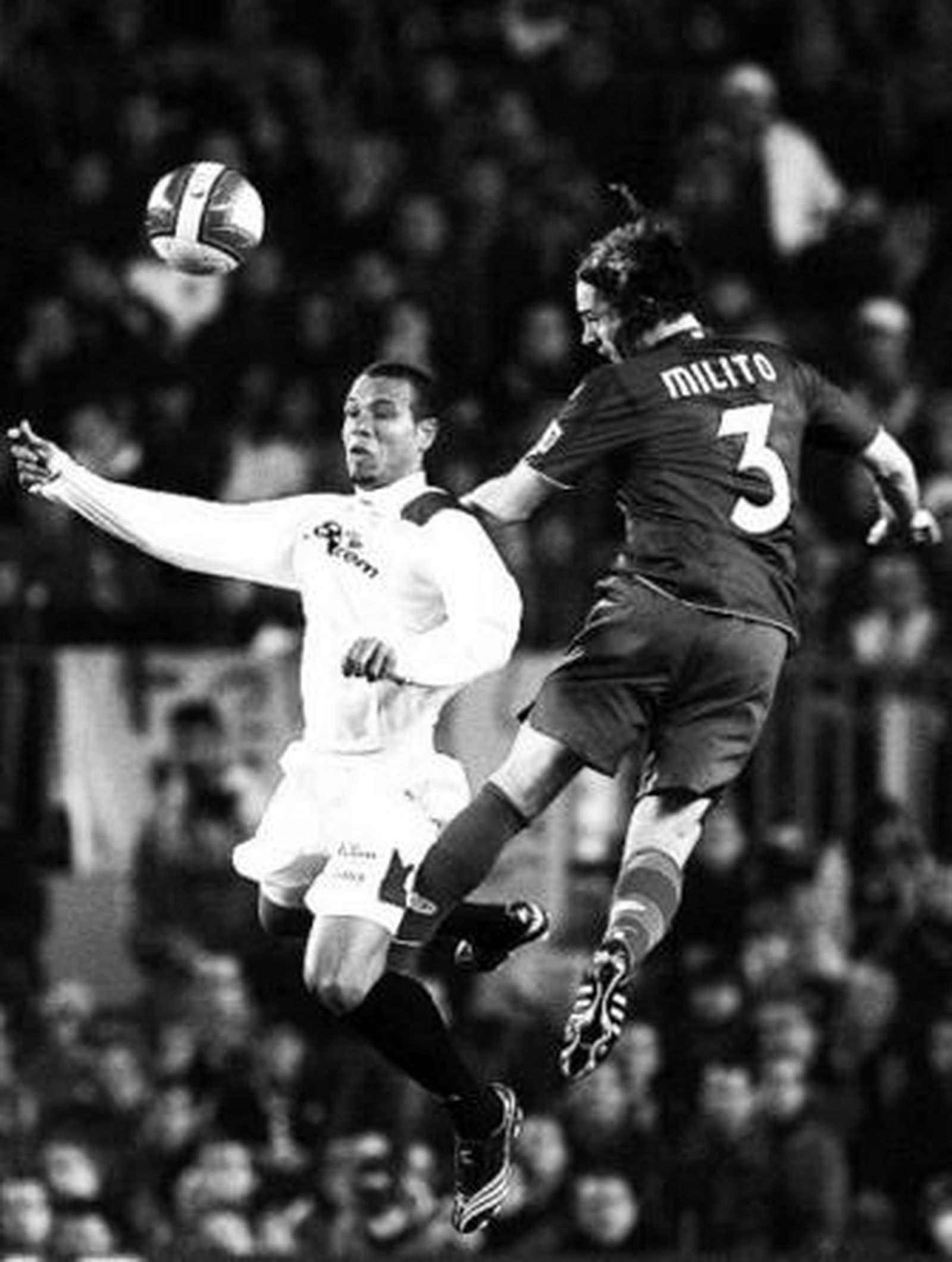 Luis Fabiano y Milito saltan en un lance del partido.