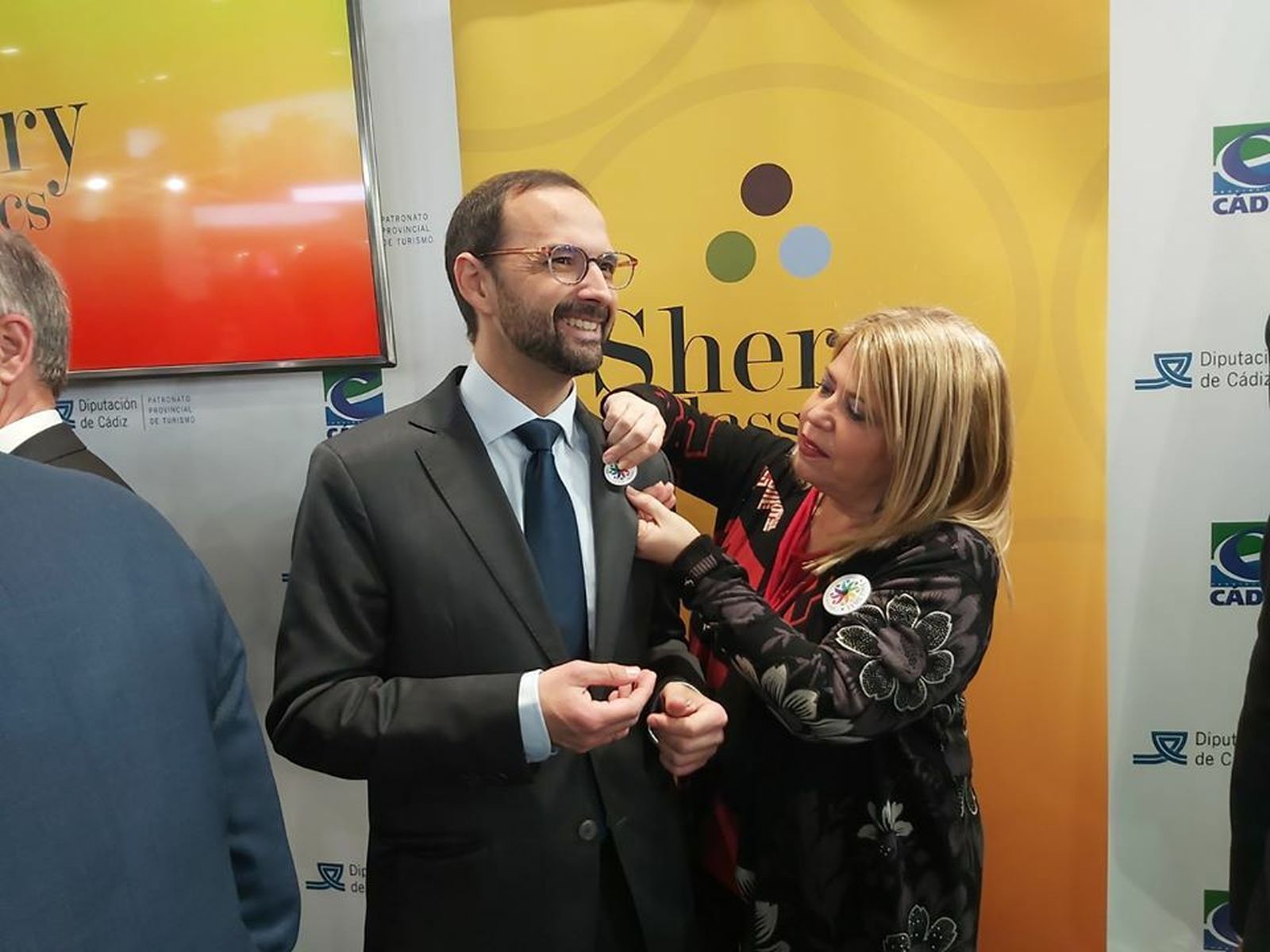 Mamen Sánchez, colocando el pin al alcalde de Sanlúcar.