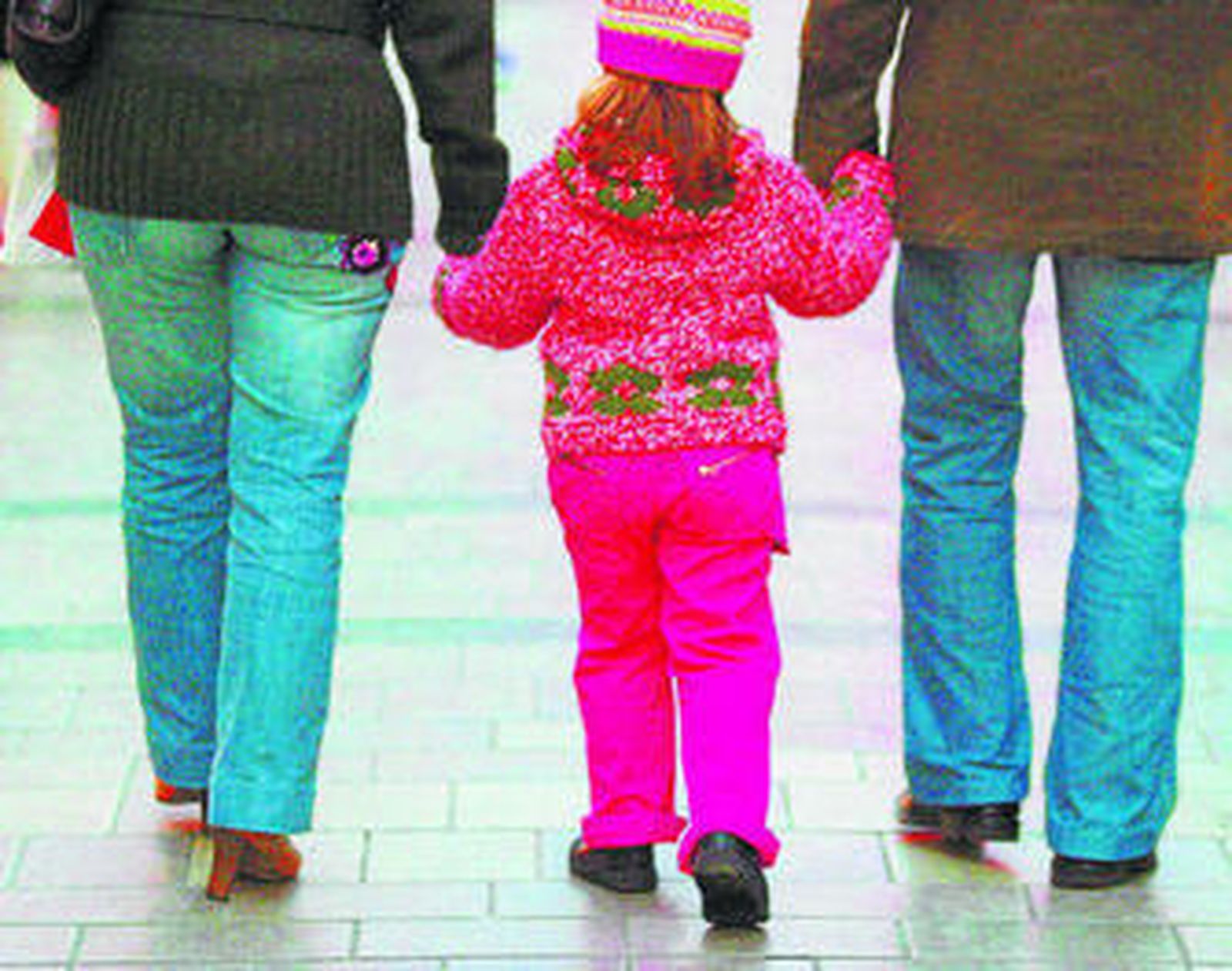 Una menor pasea con sus dos progenitores.