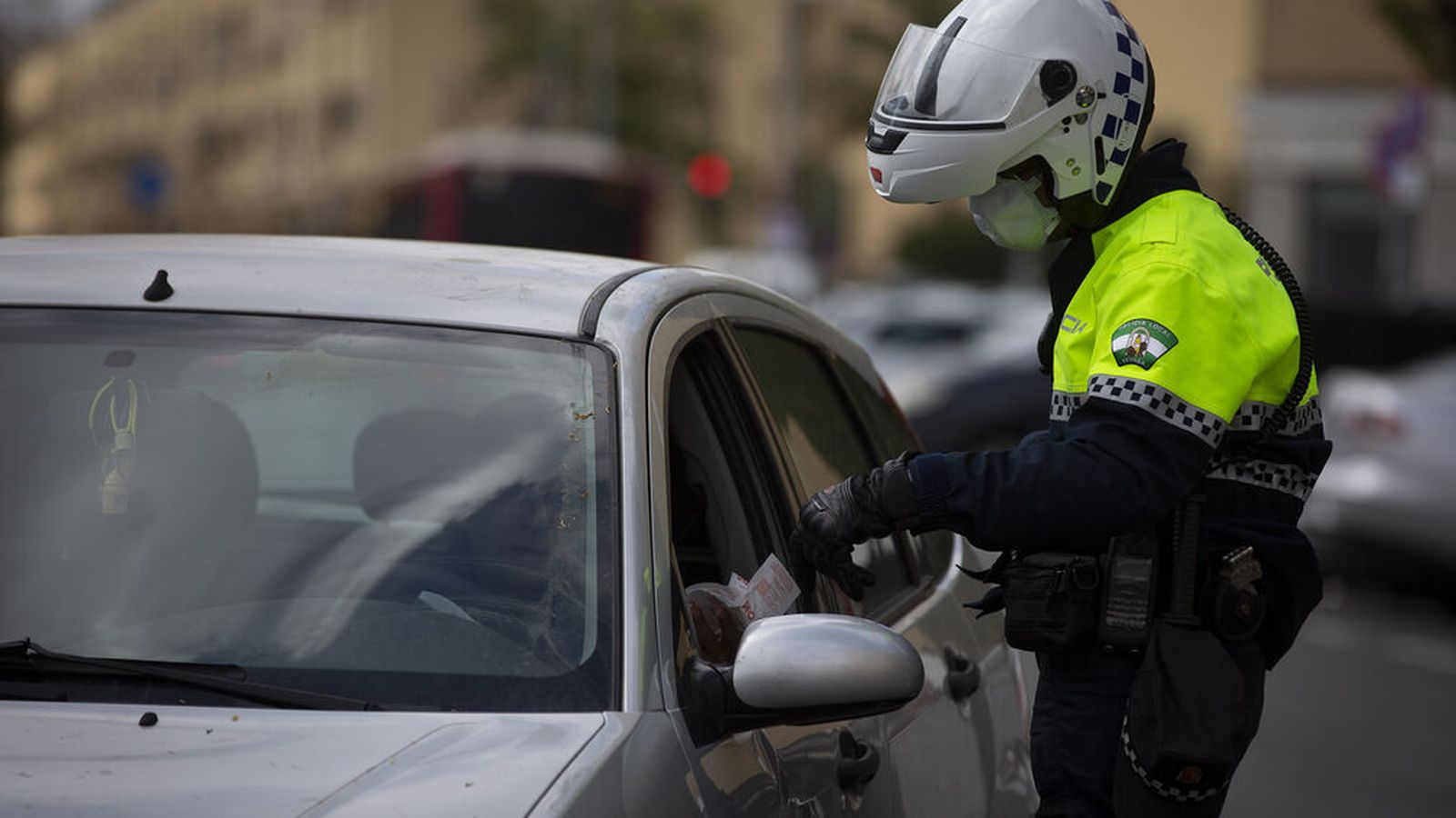 Un agente comprueba la justificación de un conductor en Sevilla.