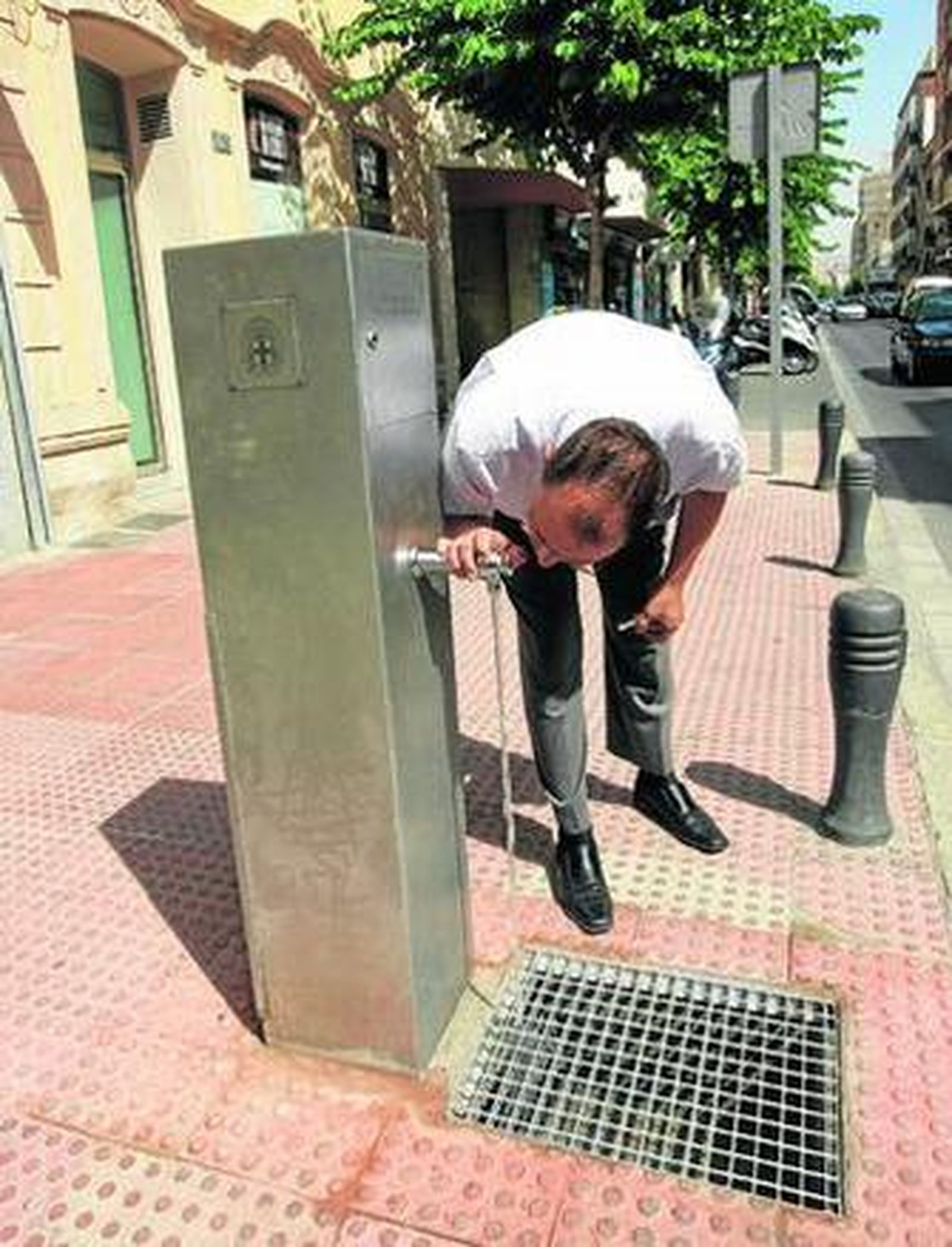 Un hombre aprovecha uno de los puntos de control instalados para saciar su sed.