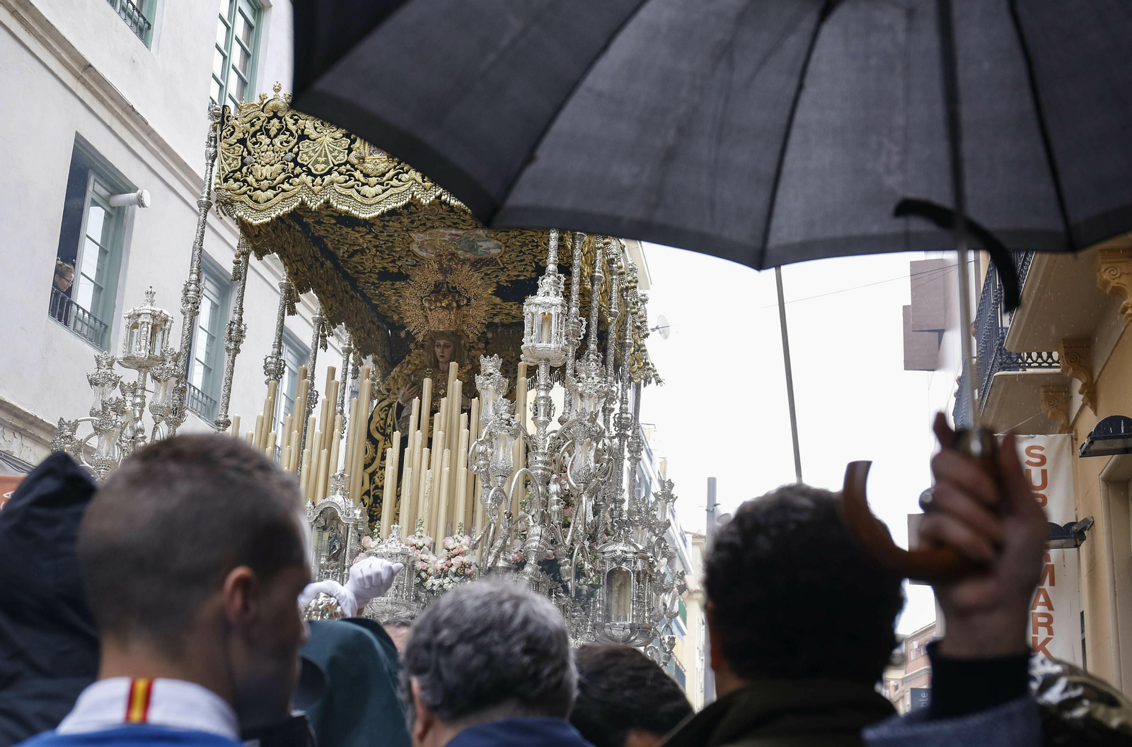 Un hombre con un paraguas ante la Virgen de Lágrimas y Favores en Domingo de Ramos de 2018