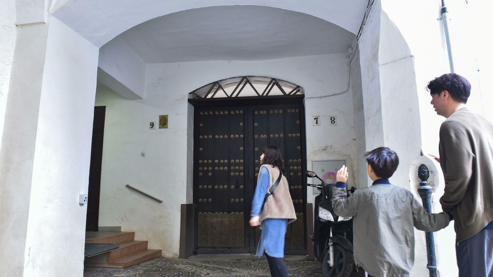 Varias personas junto a la entrada principal de la casa enclavada en los números 7 y 8.