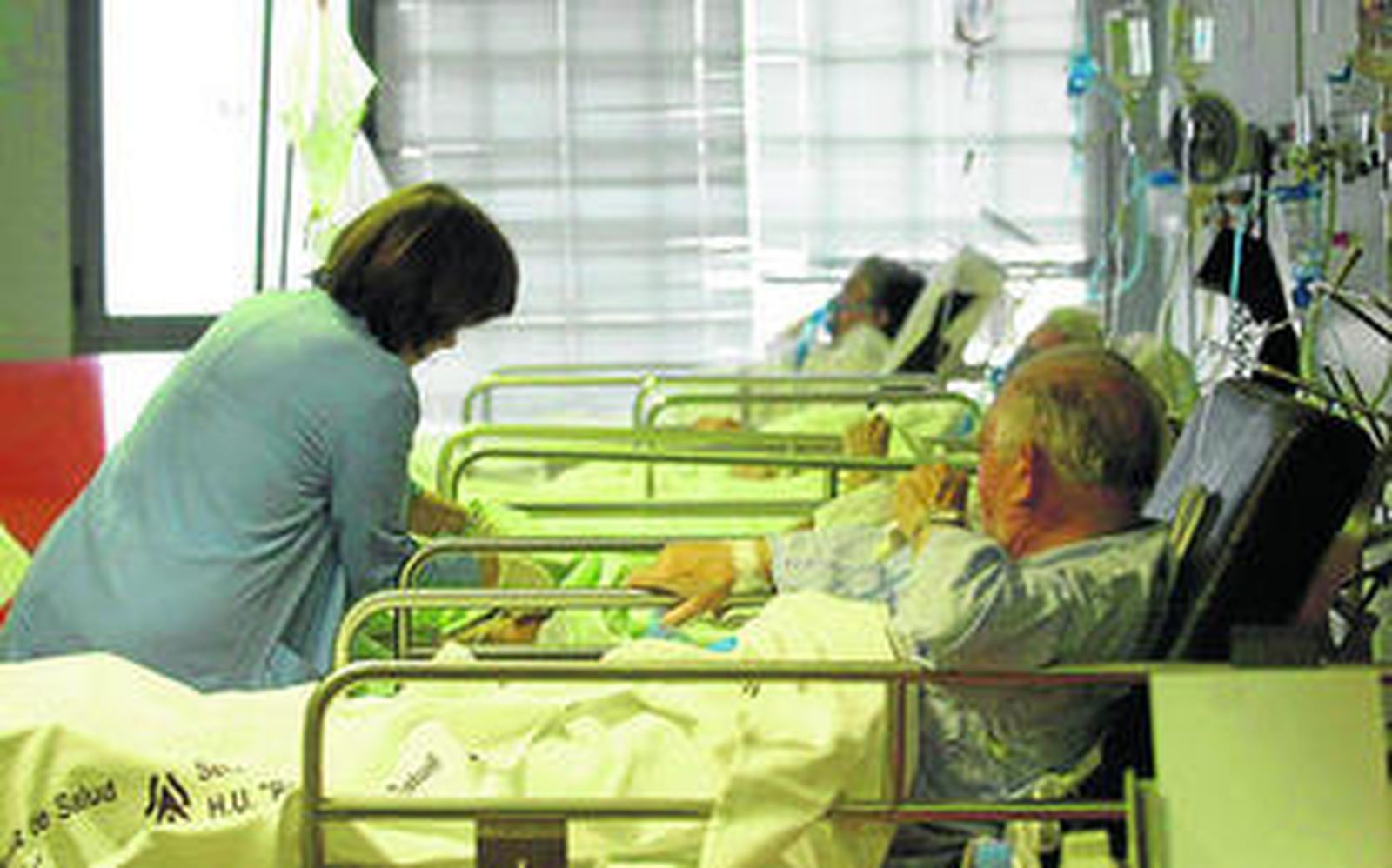 Una profesional sanitaria atiende a varios pacientes en el Servicio de Urgencias.