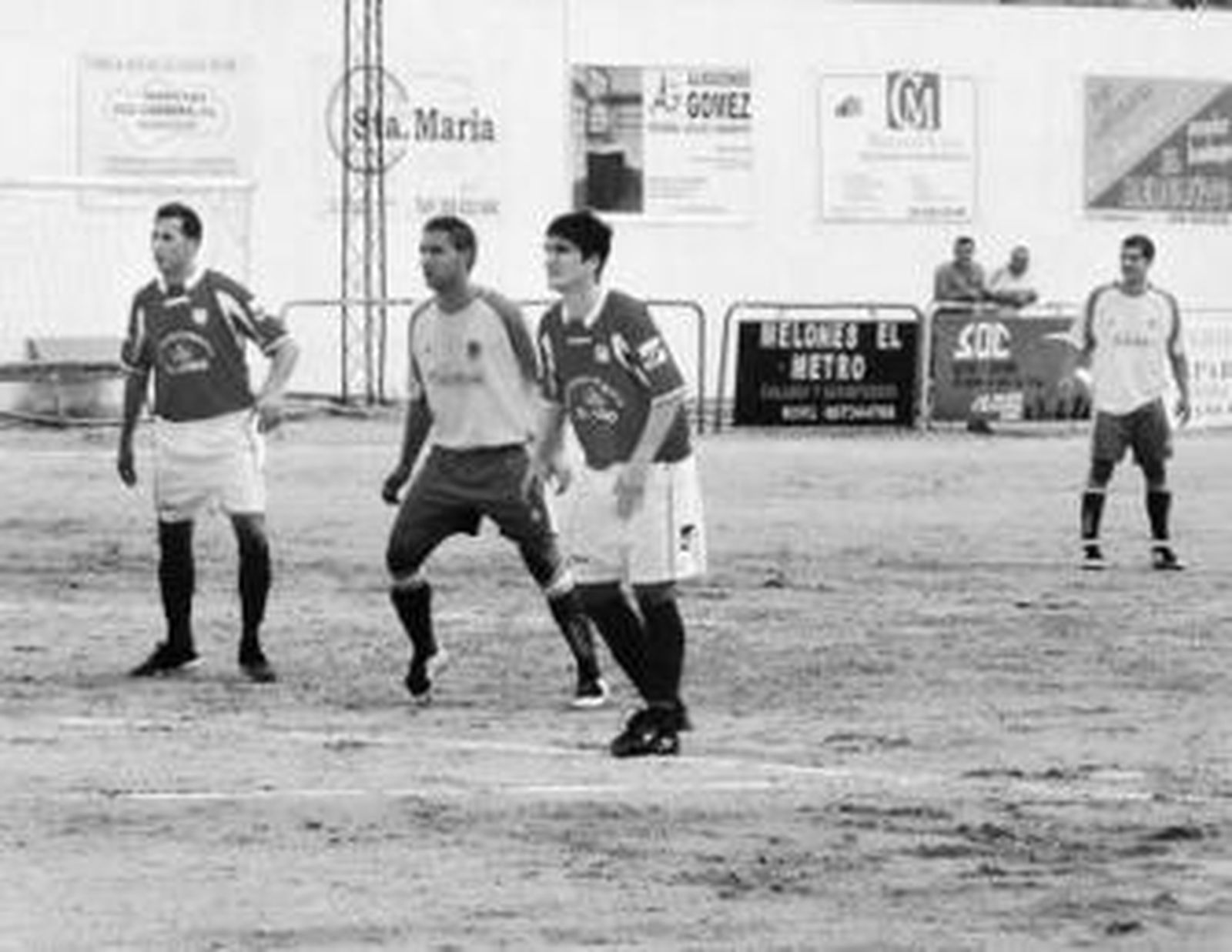 Dos jugadores del Abre rodean a un adversario a la espera del balón.