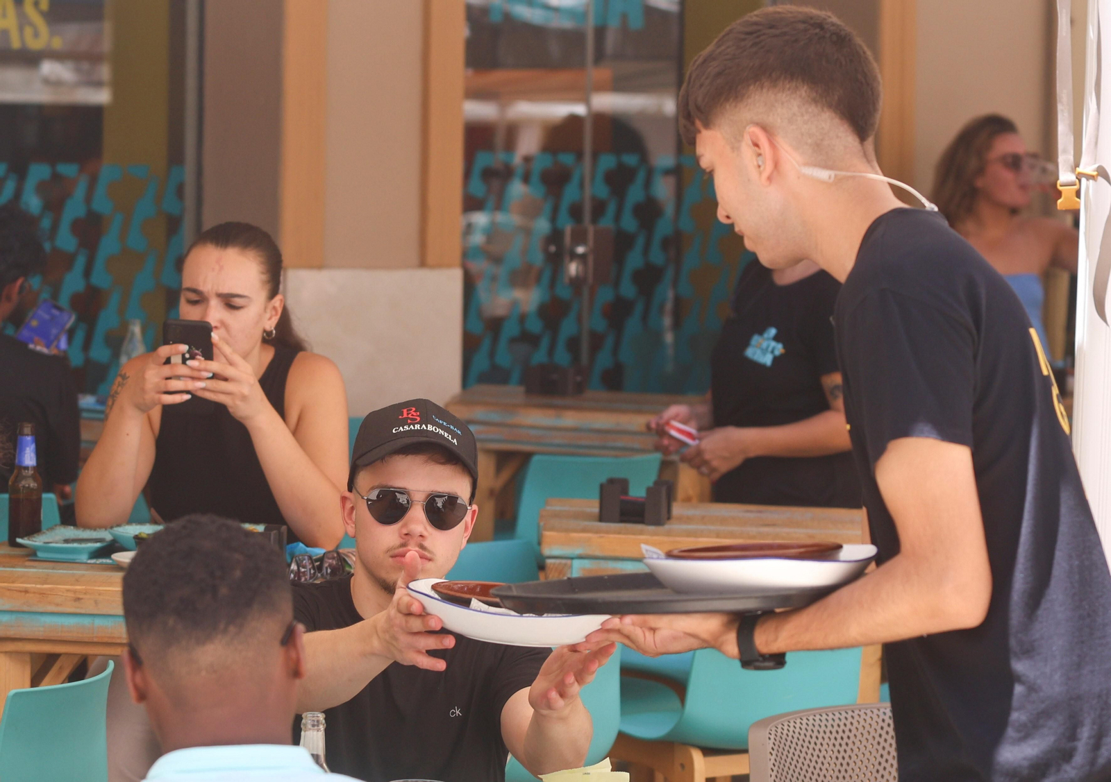 Un camarero atiende a una mesa en un restaurante del centro de Málaga.