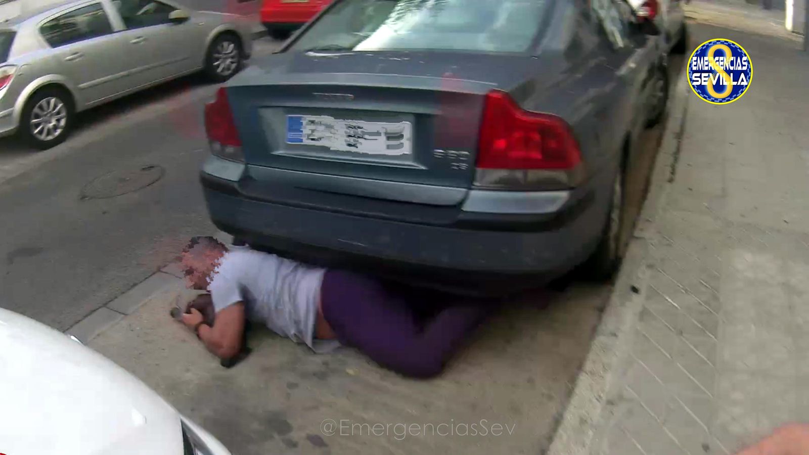 El detenido tratando de huir escondido bajo un coche.