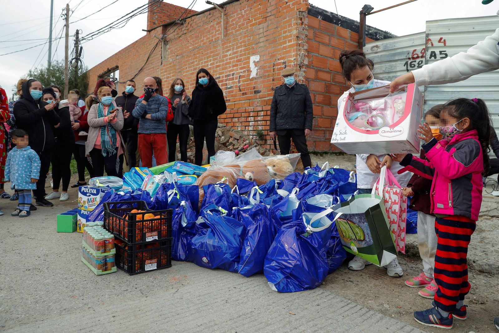 La Fundación Madrina entrega a niños alimentos y material infantil en la Cañada Real (Madrid).
