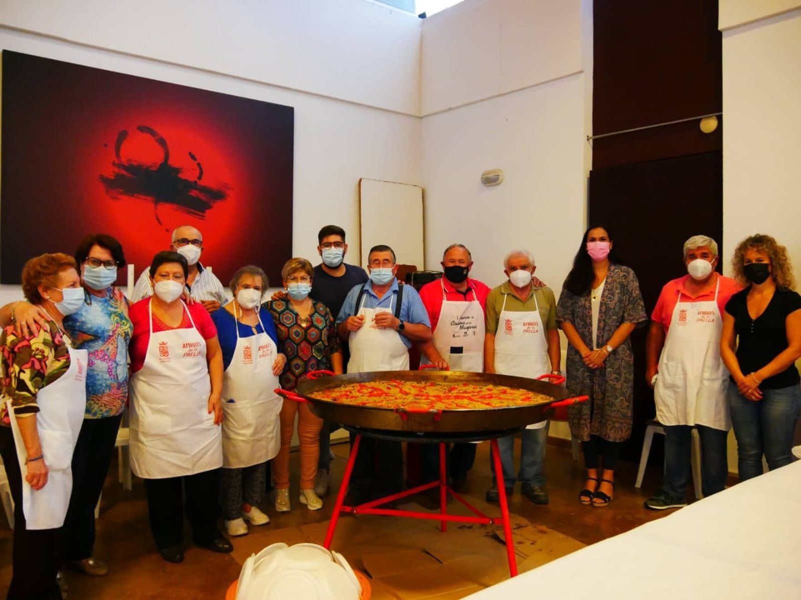Un grupo de mayores de El Carpio, junto a una de las paellas degustadas.