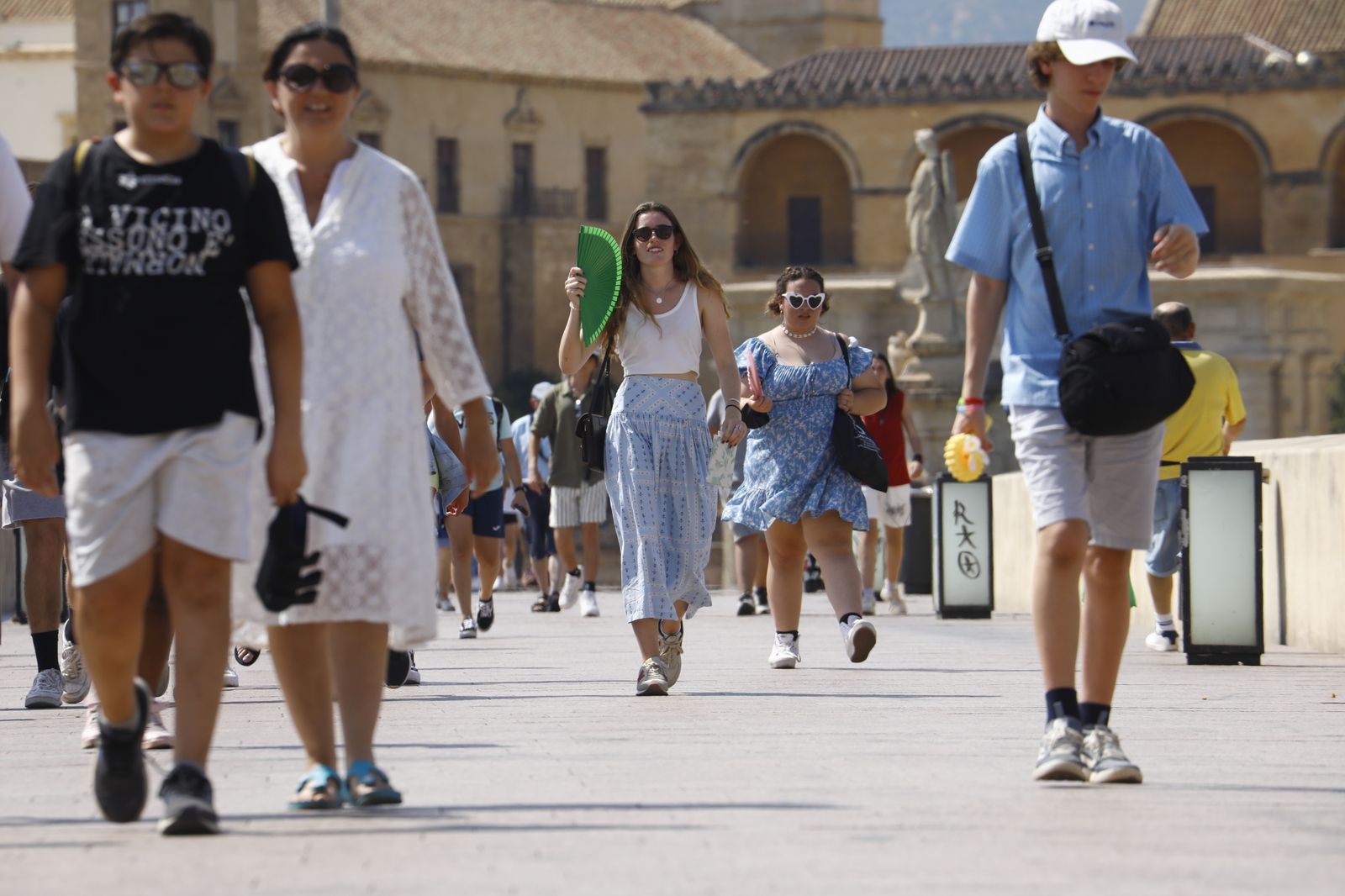 Varias personas caminan por el Puente Romano de Córdoba.