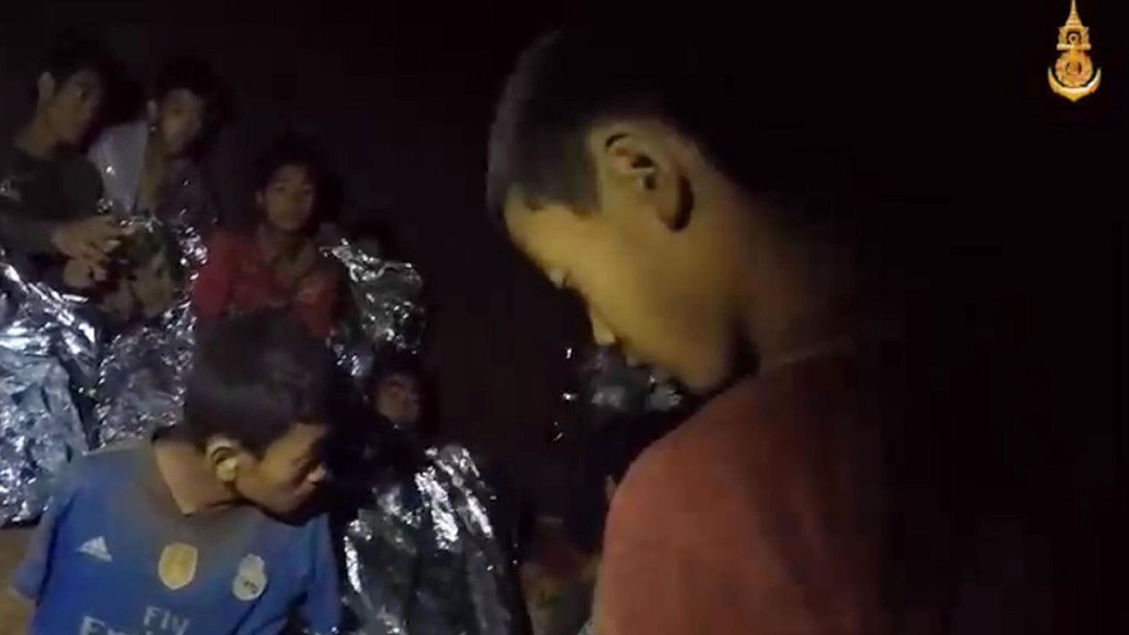 Varios de los niños atrapados en la cueva tailandesa se abrigan con mantas términas para paliar el frío.