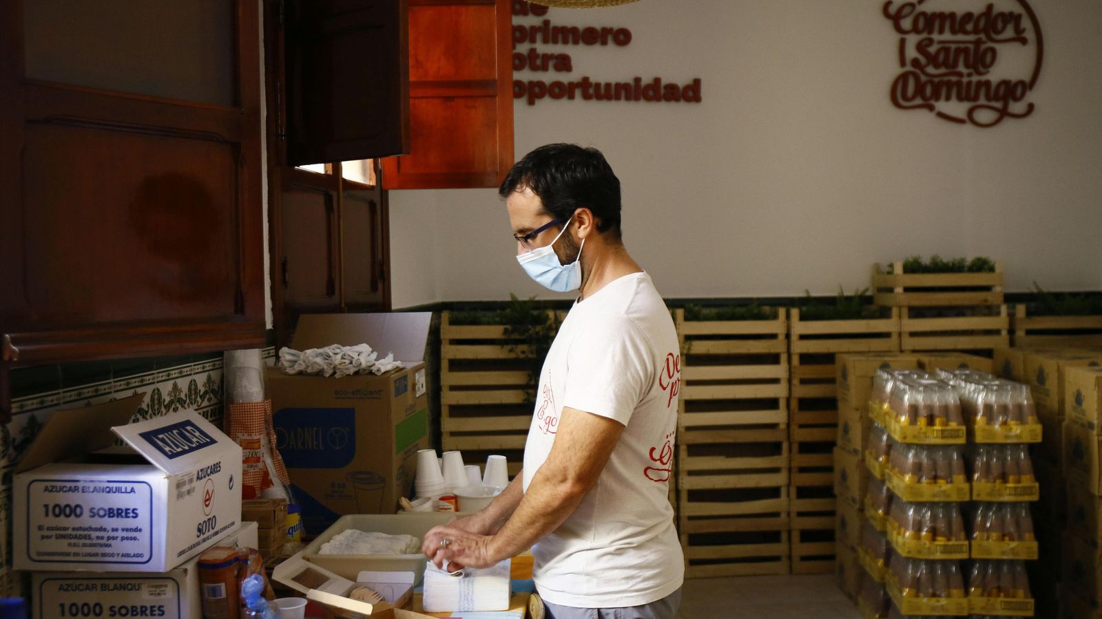 Un voluntario elabora lotes con productos para su entrega.