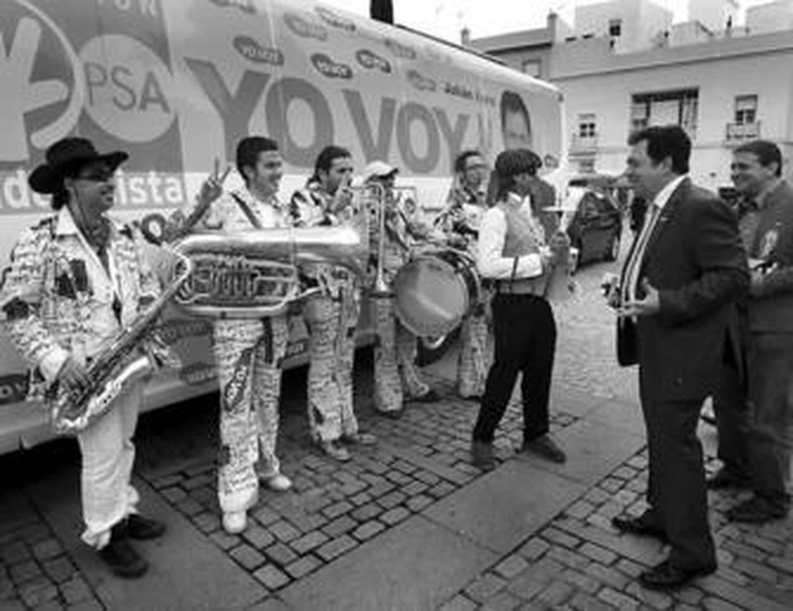 Julián Álvarez escucha a la banda que animó ayer su recorrido por las calles de Cádiz.