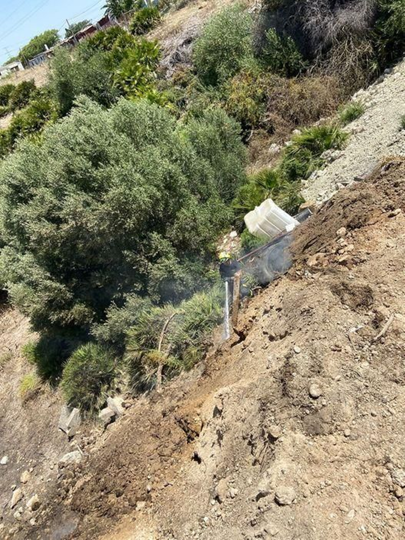 Un bombero refrescando la zona para evitar que se propagara el incendio.