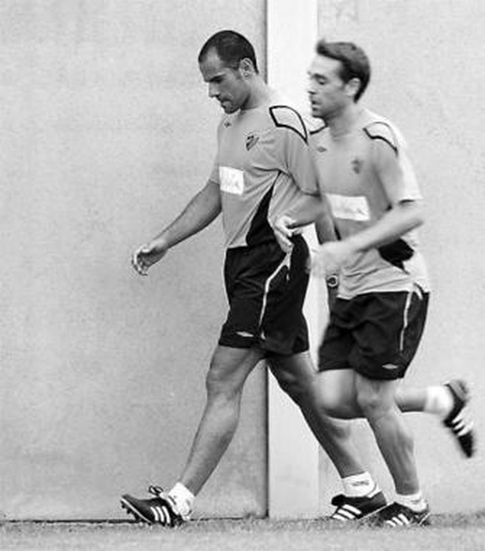 Salva, cabizbajo, se retira del entrenamiento con Nacho delante.