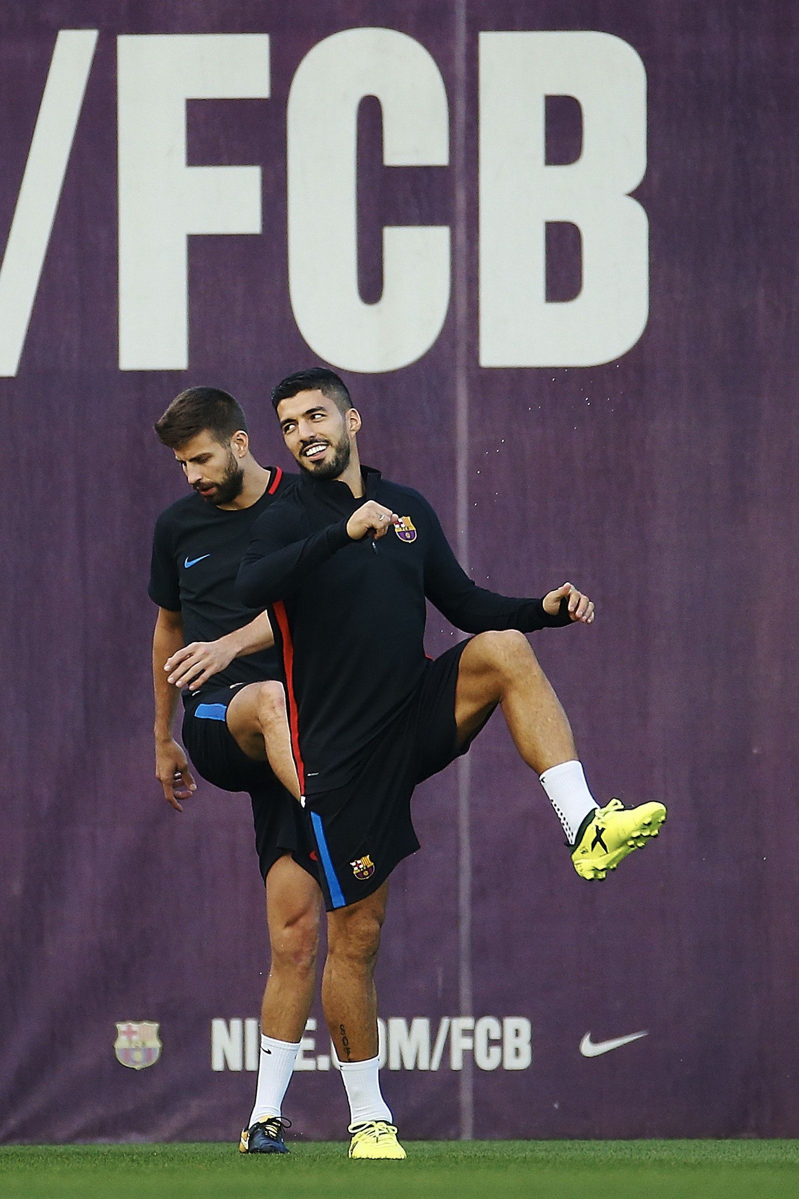 Luis Suárez, con Piqué detrás, calienta al inicio del entrenamiento de ayer.