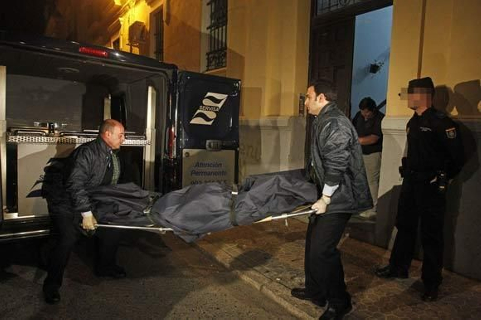 Dos empleados de los servicios funerarios retiran el cadáver de Carmen Redondo.

Foto: Antonio Pizarro