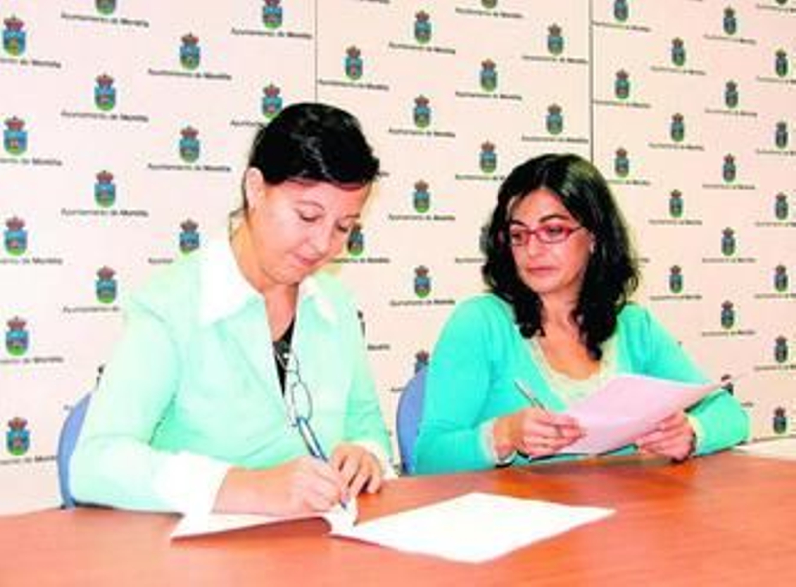 Tránsito Jiménez y Rosa Lucía Polonio firman el acuerdo.